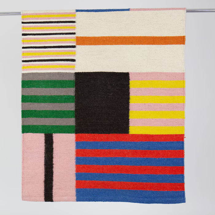 Colorful geometric patterned rug on a white background