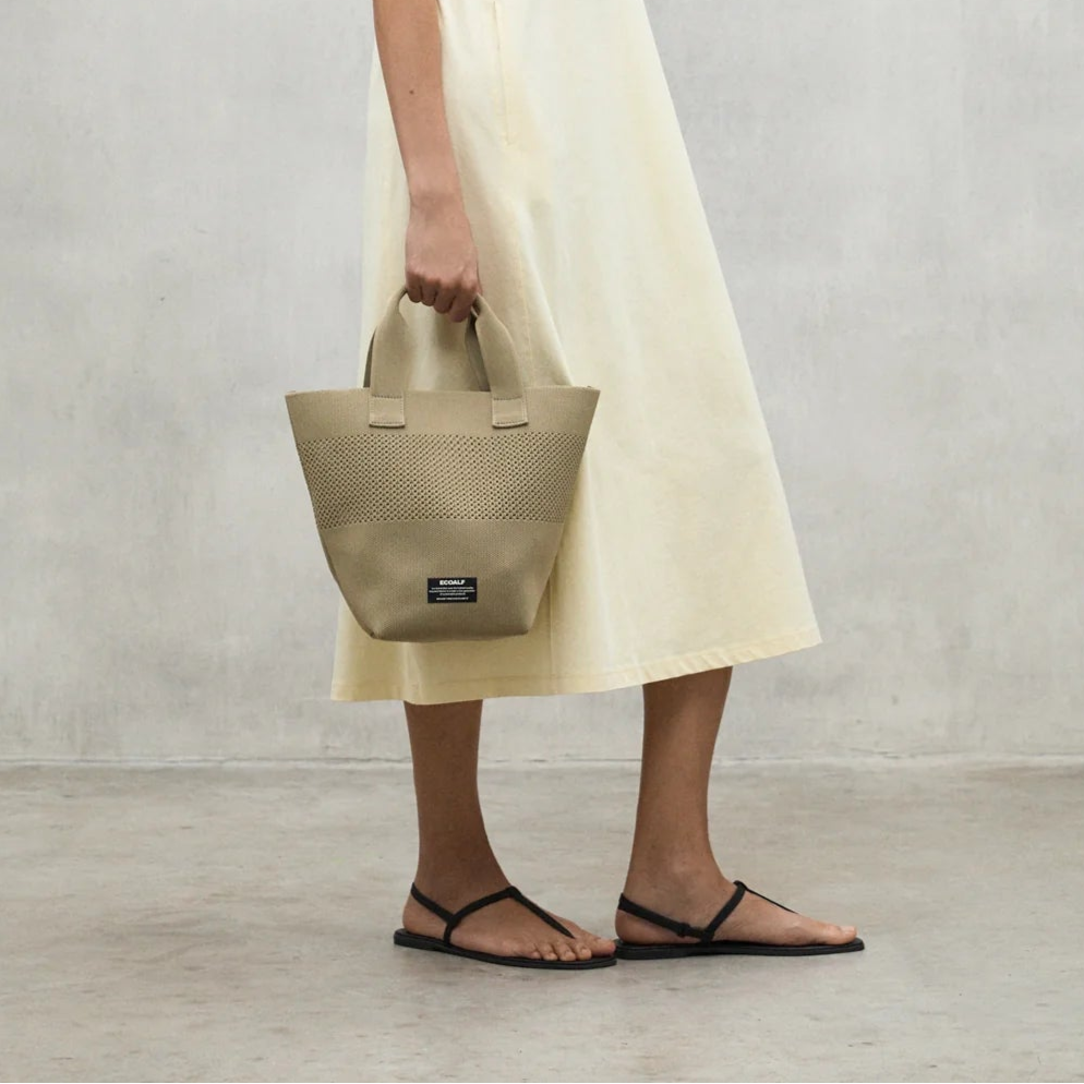 Beige tote bag with perforated detail and short handles.