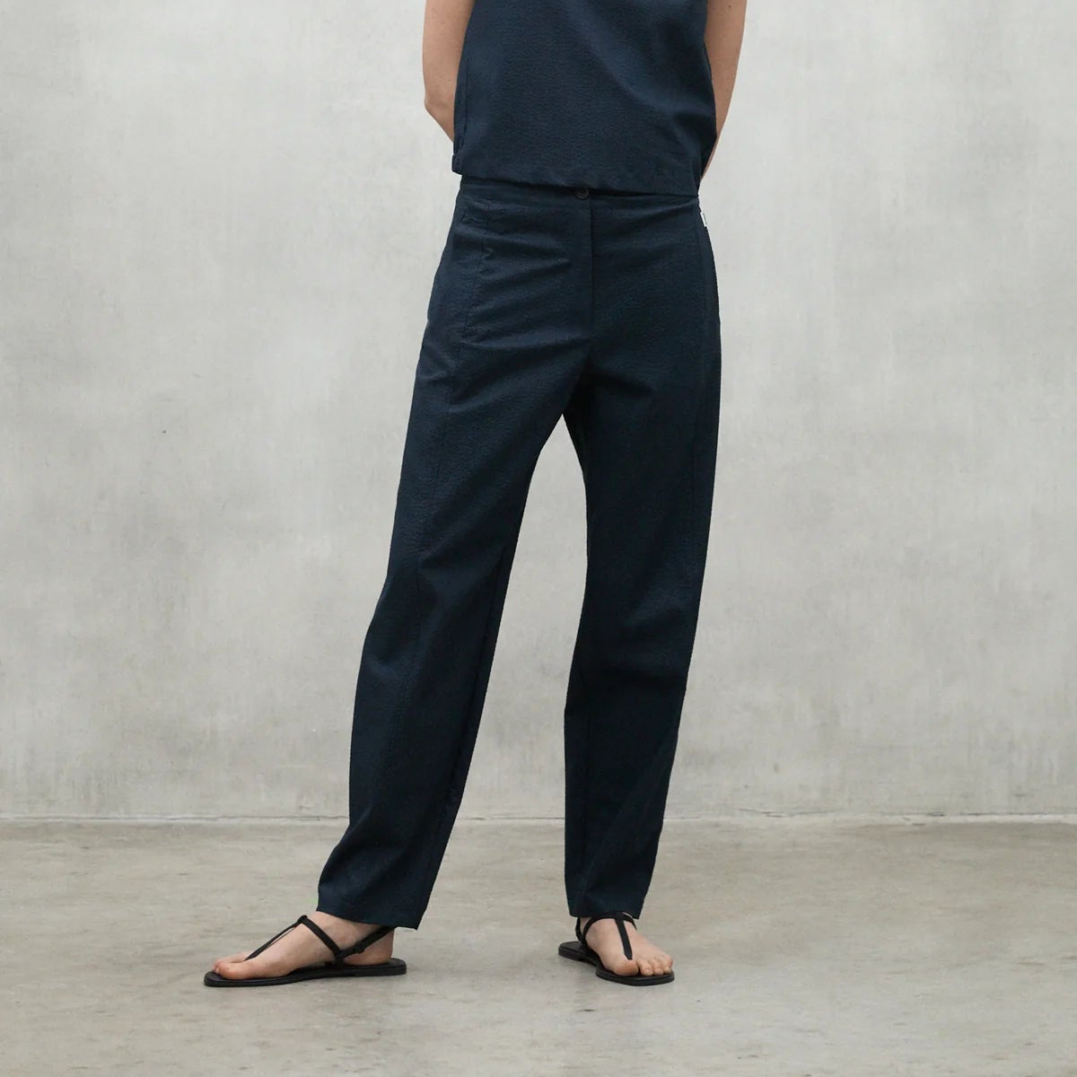 Dark navy blue high-waisted straight-leg pants with a textured surface.
