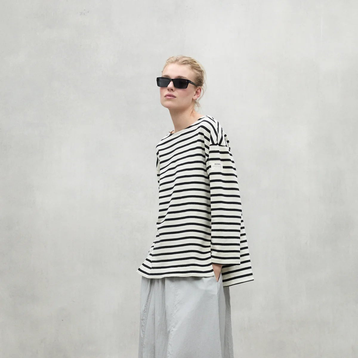 Cream-colored long-sleeved Breton top with black horizontal stripes.