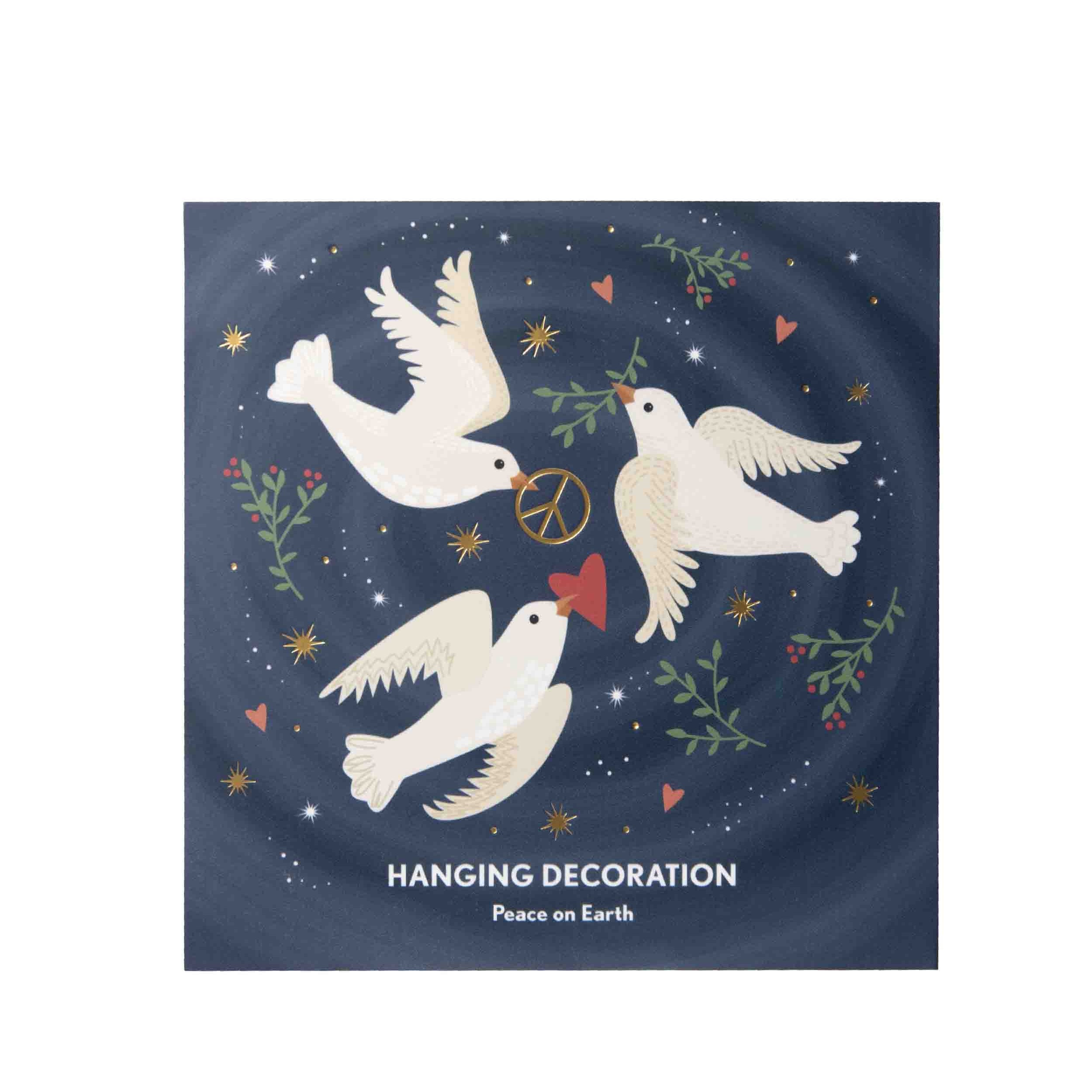 A square hanging decoration featuring a navy blue background with three white doves, small red hearts, green leaves, and gold stars. The text 'HANGING DECORATION' and 'Peace on Earth' is printed at the bottom.