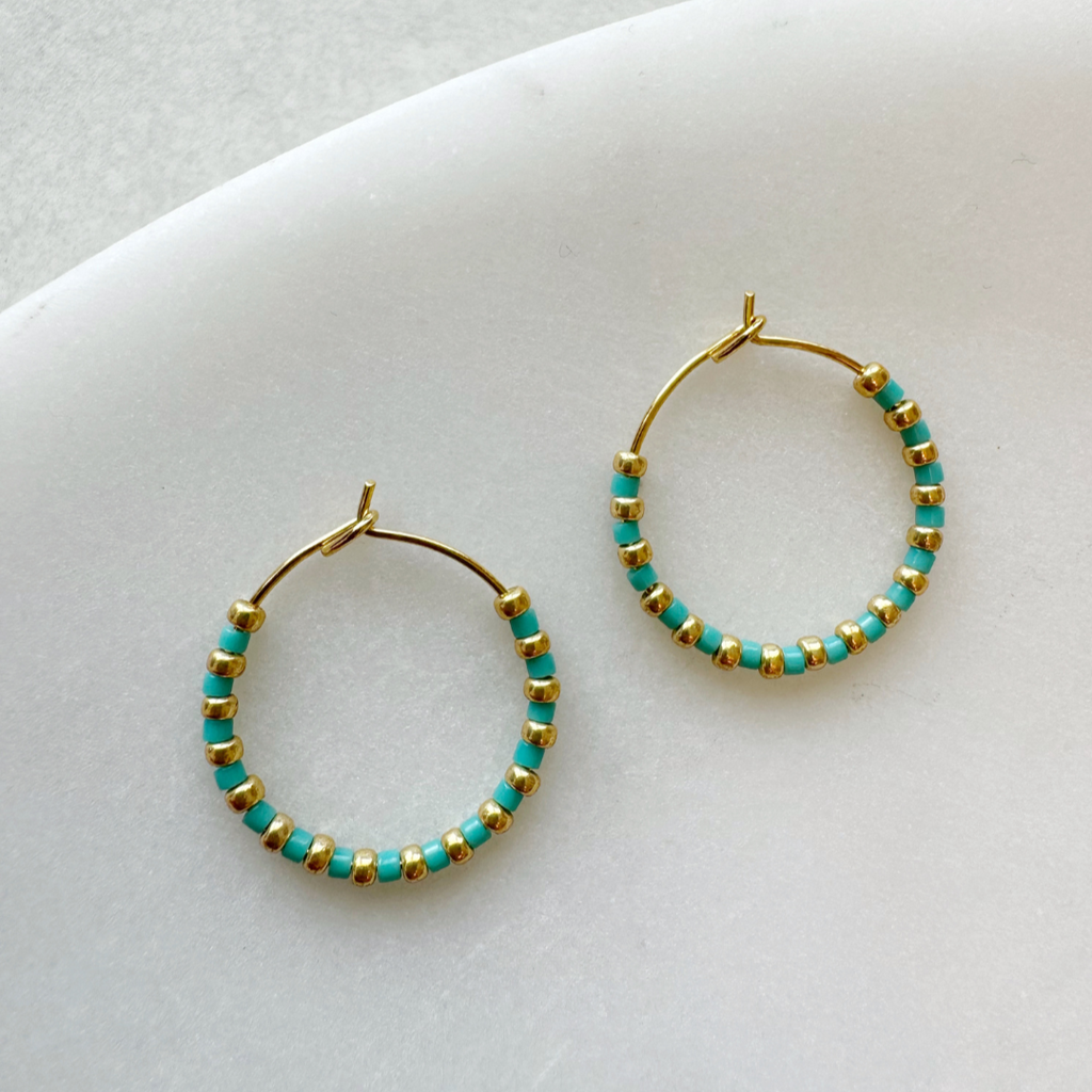 Gold hoop earrings adorned with alternating turquoise and gold beads.