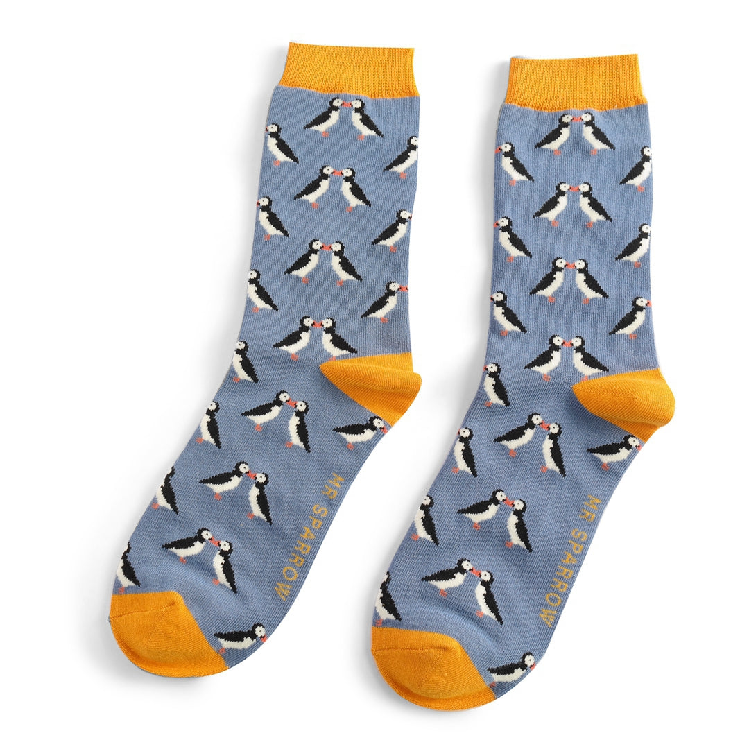 Pair of blue socks with a repeating pattern of kissing puffins.  Mustard yellow cuffs.  "Mrs Sparrow" branding visible.