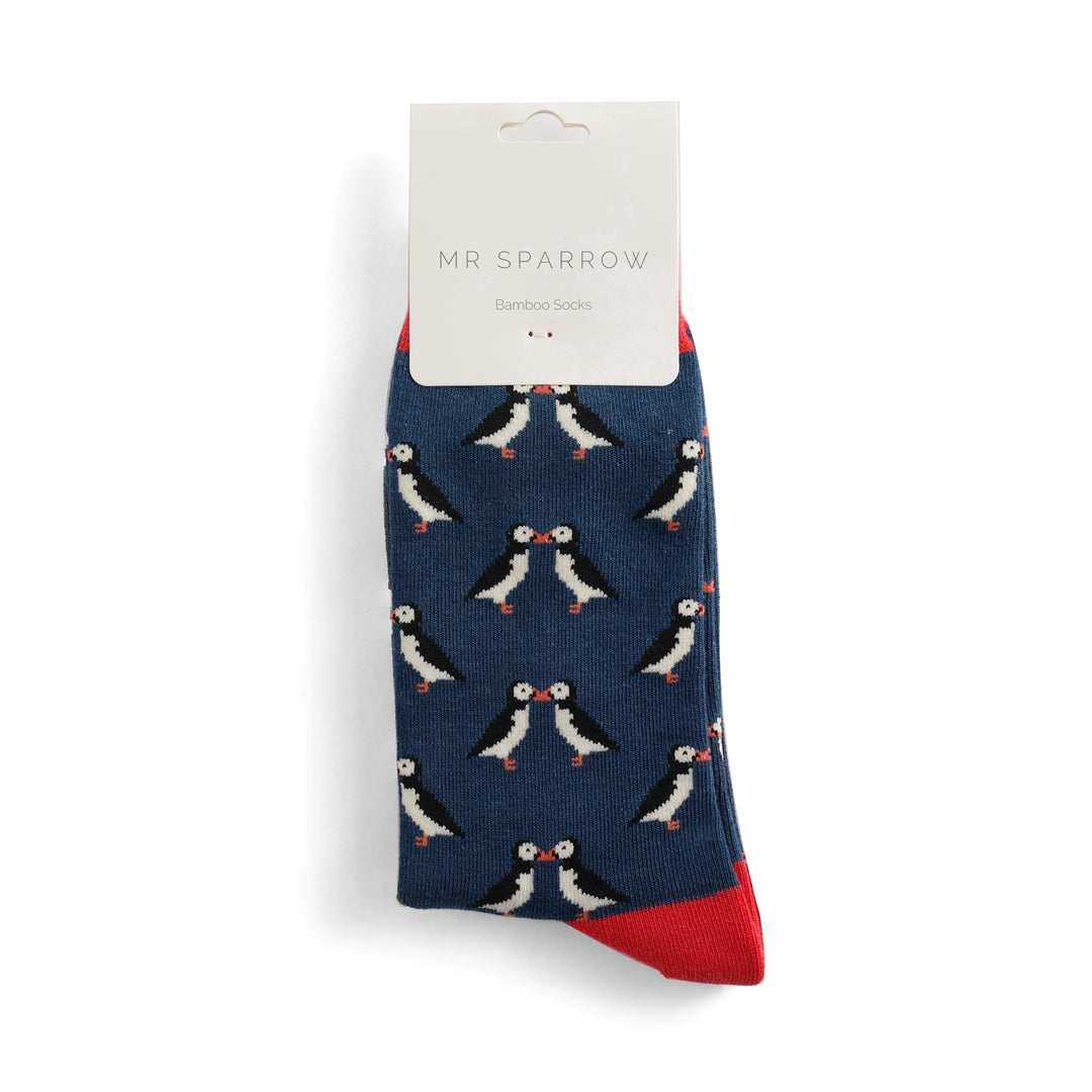 Mr Sparrow bamboo socks with a navy blue background and a repeating pattern of kissing puffins.  Red sock cuff.