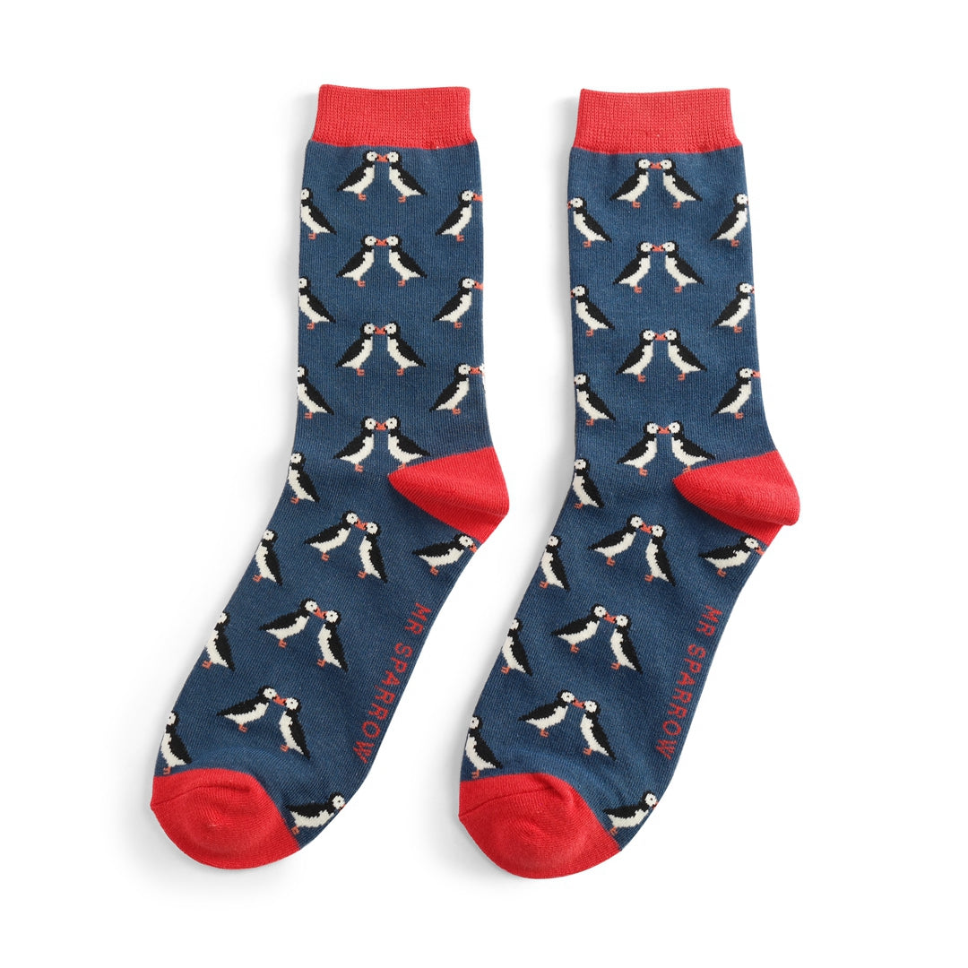 Pair of blue socks with red cuffs featuring a repeating pattern of kissing puffins.