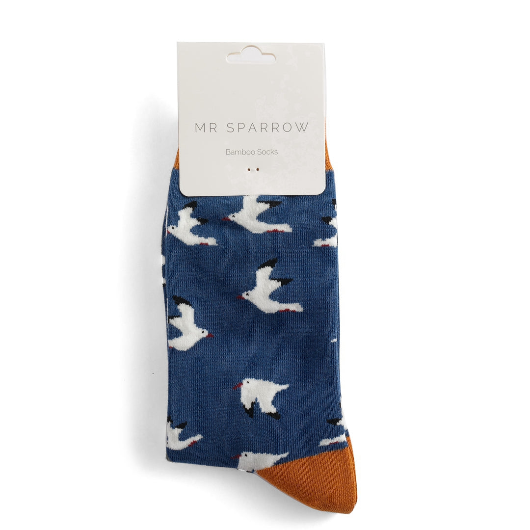 Pair of blue bamboo socks featuring a white seagull pattern and mustard yellow heel and toe.  Mr. Sparrow brand.