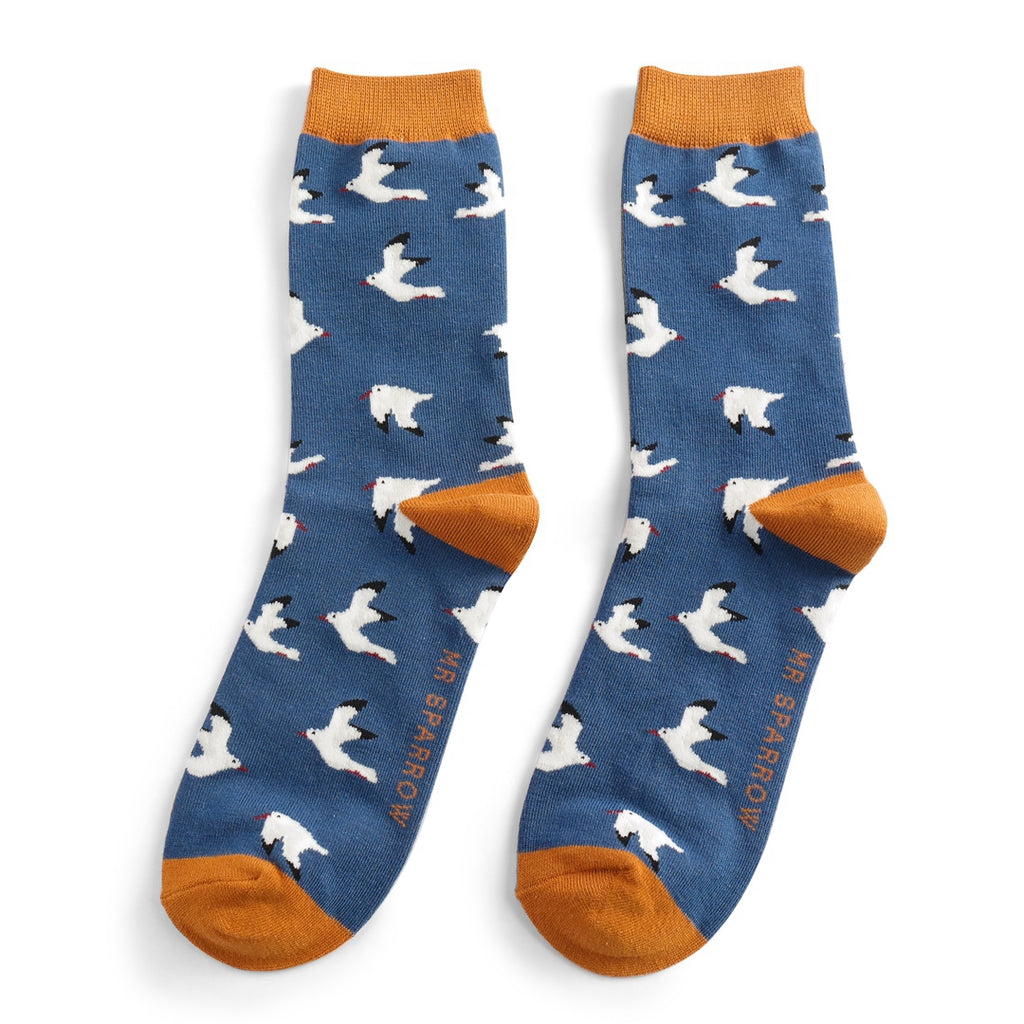 Pair of blue socks with a repeating pattern of white birds.  Mustard yellow cuffs. "Mr Sparrow" branding visible.