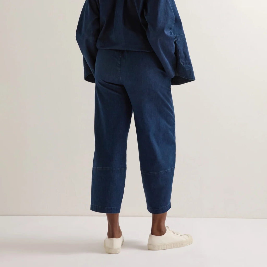 Person wearing a navy Sahara outfit with cropped pants and a long-sleeve shirt, paired with white sneakers.