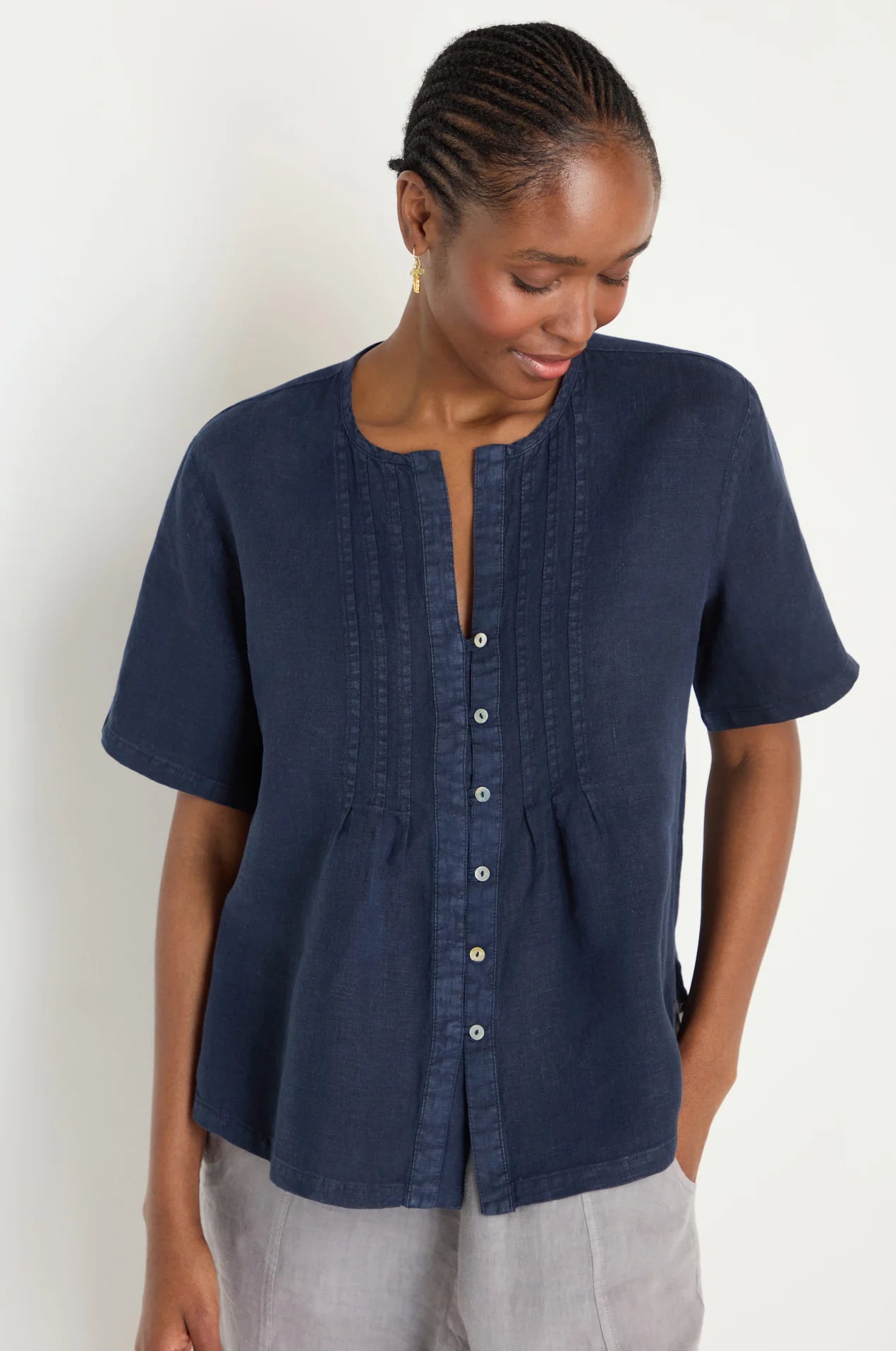 Woman wearing a navy blue blouse with a plain background