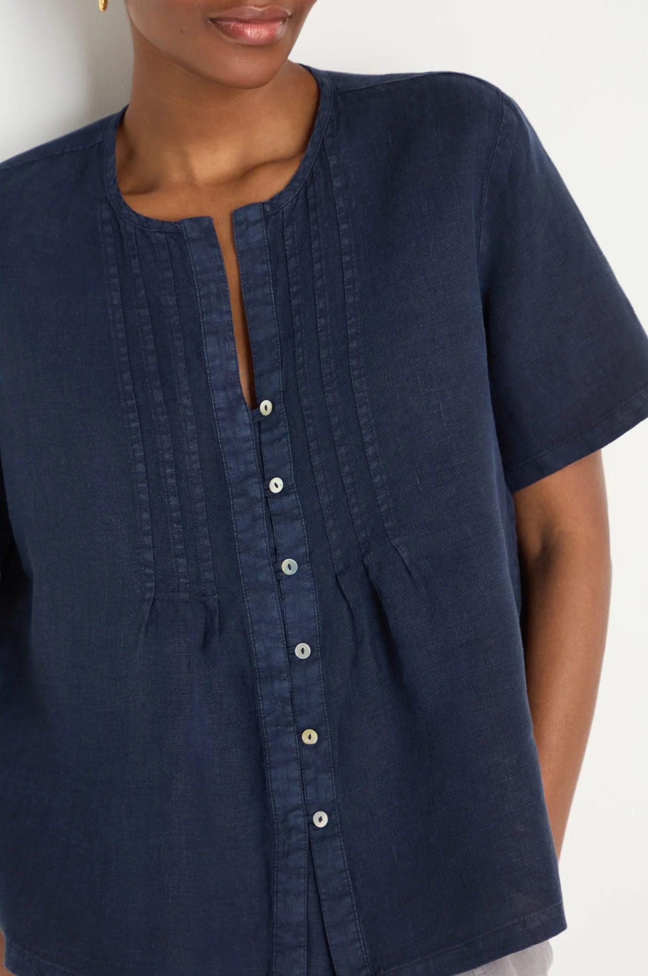 Navy blue shirt with button details on a white background