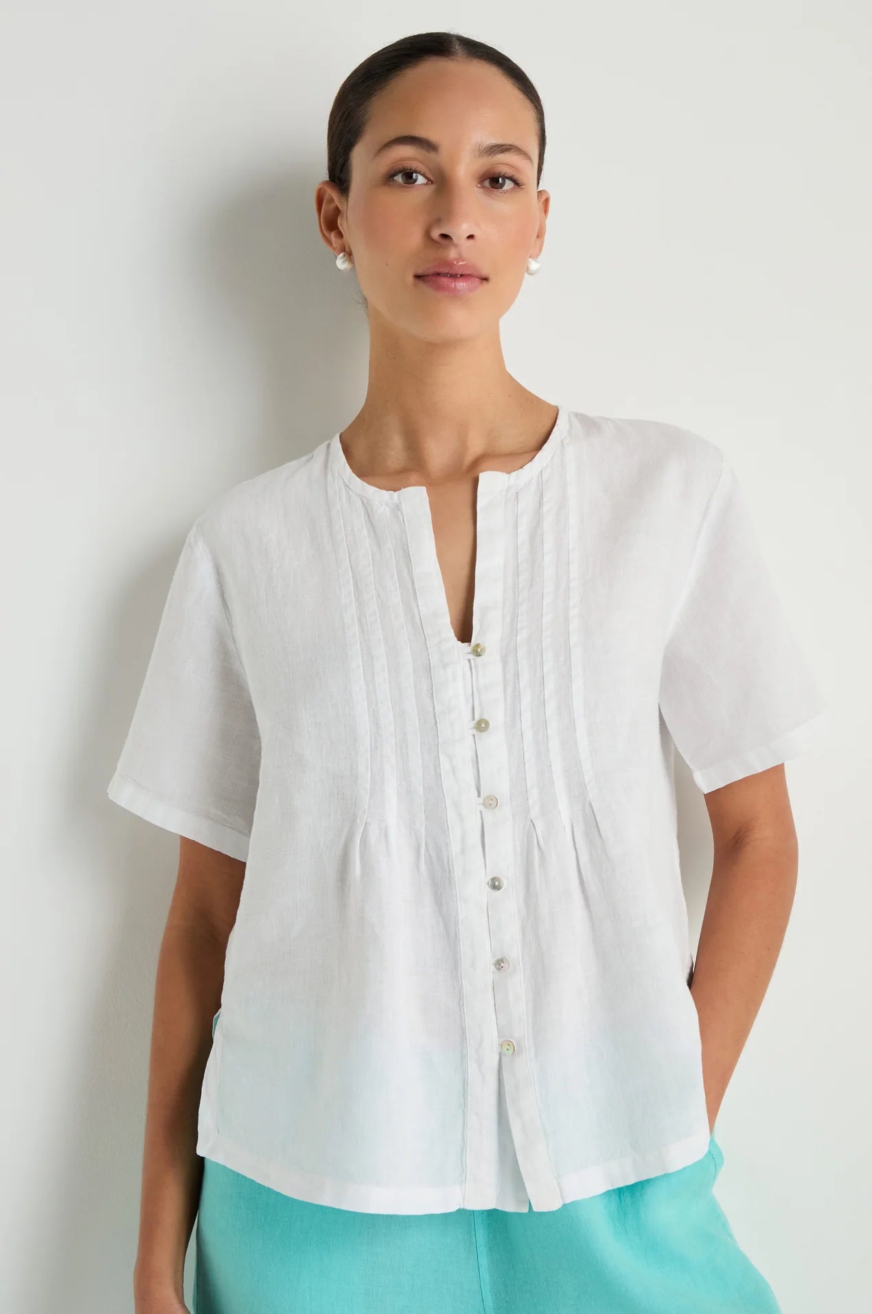 Woman wearing a white blouse with a plain background