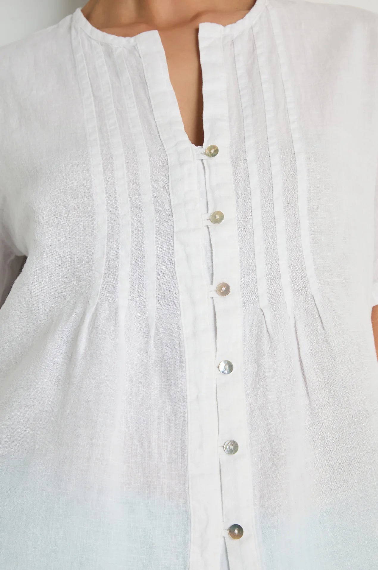 Close-up of a white button-up shirt with a blurred background