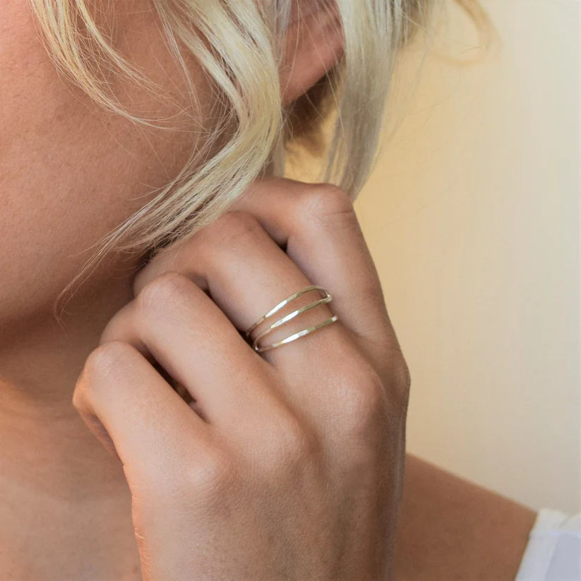Silver three-band ring with hammered texture, slightly curved bands.