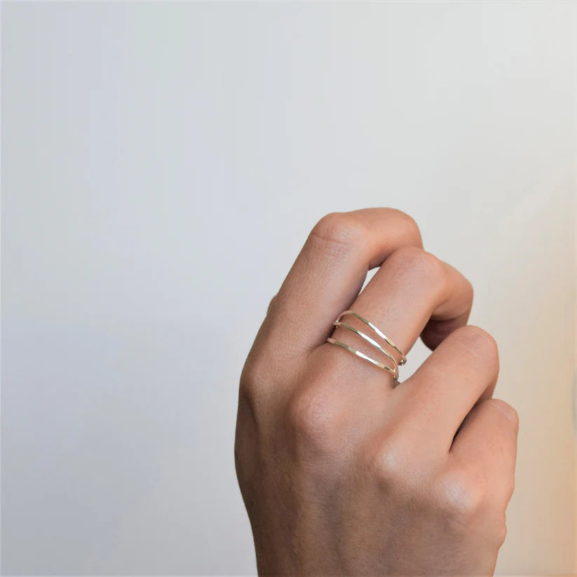 Silver three-band ring with hammered texture.