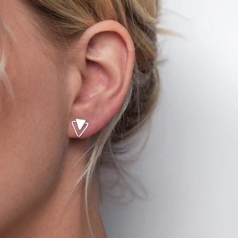 Silver triangle stud earrings; a smaller triangle sits inside a larger one.