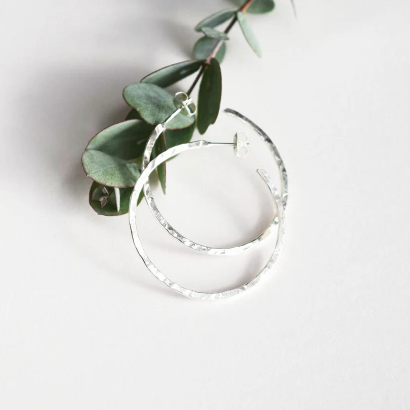 Silver hammered hoop earrings.  Textured metal, circular design.