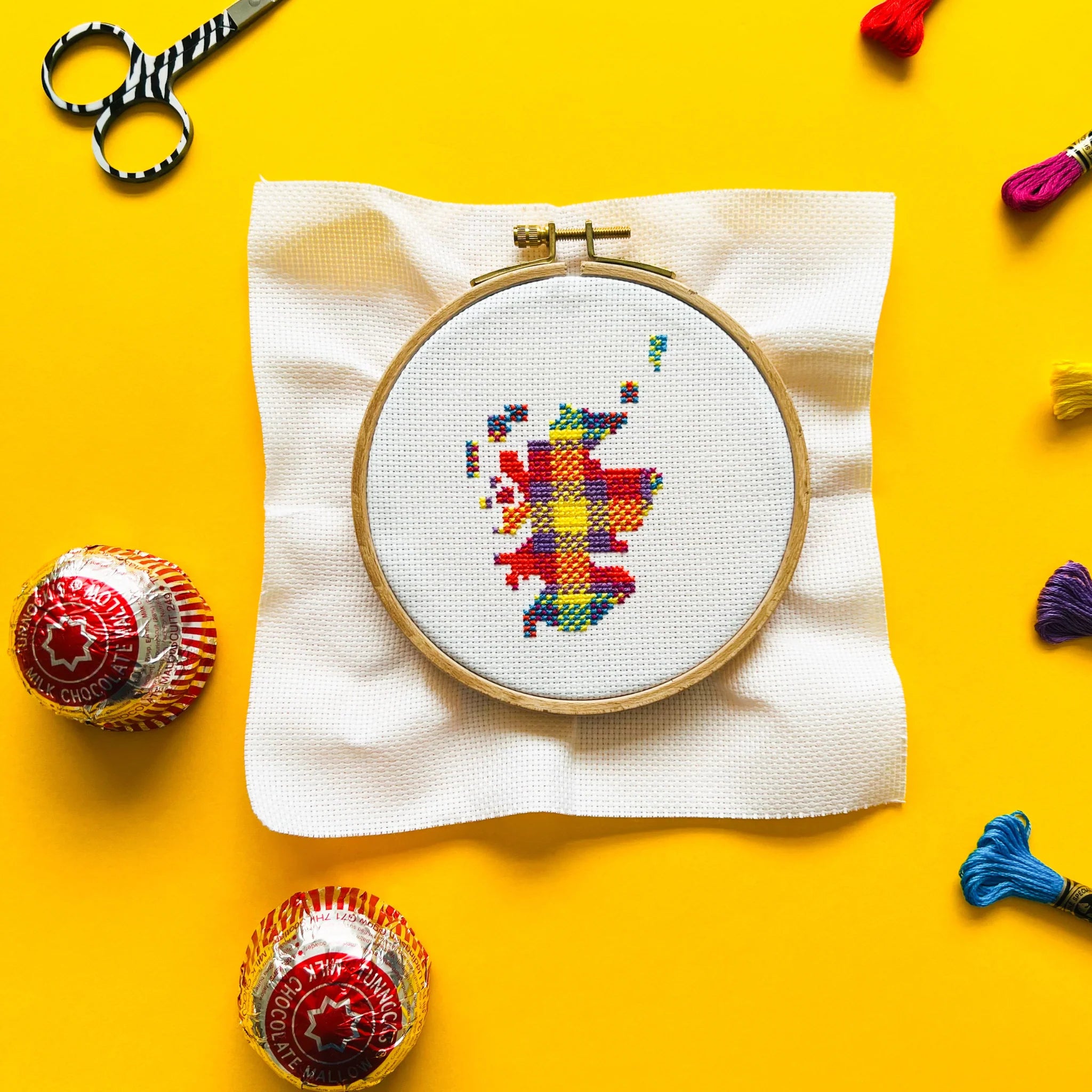 Cross-stitch embroidery of a colorful map of Scotland in a wooden hoop.