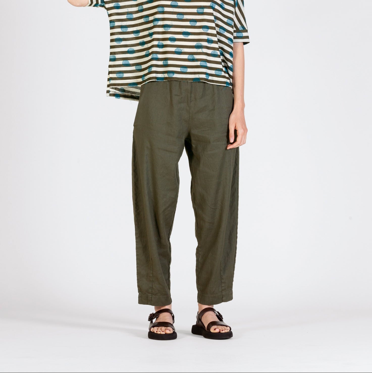 Olive green linen cropped pants with a relaxed fit, shown on a model.