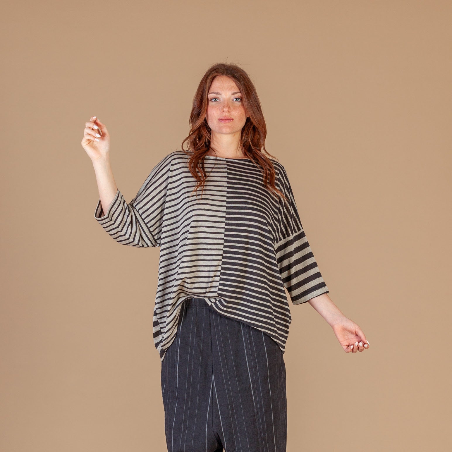 Women wearing a long beige brown and black stripe top.