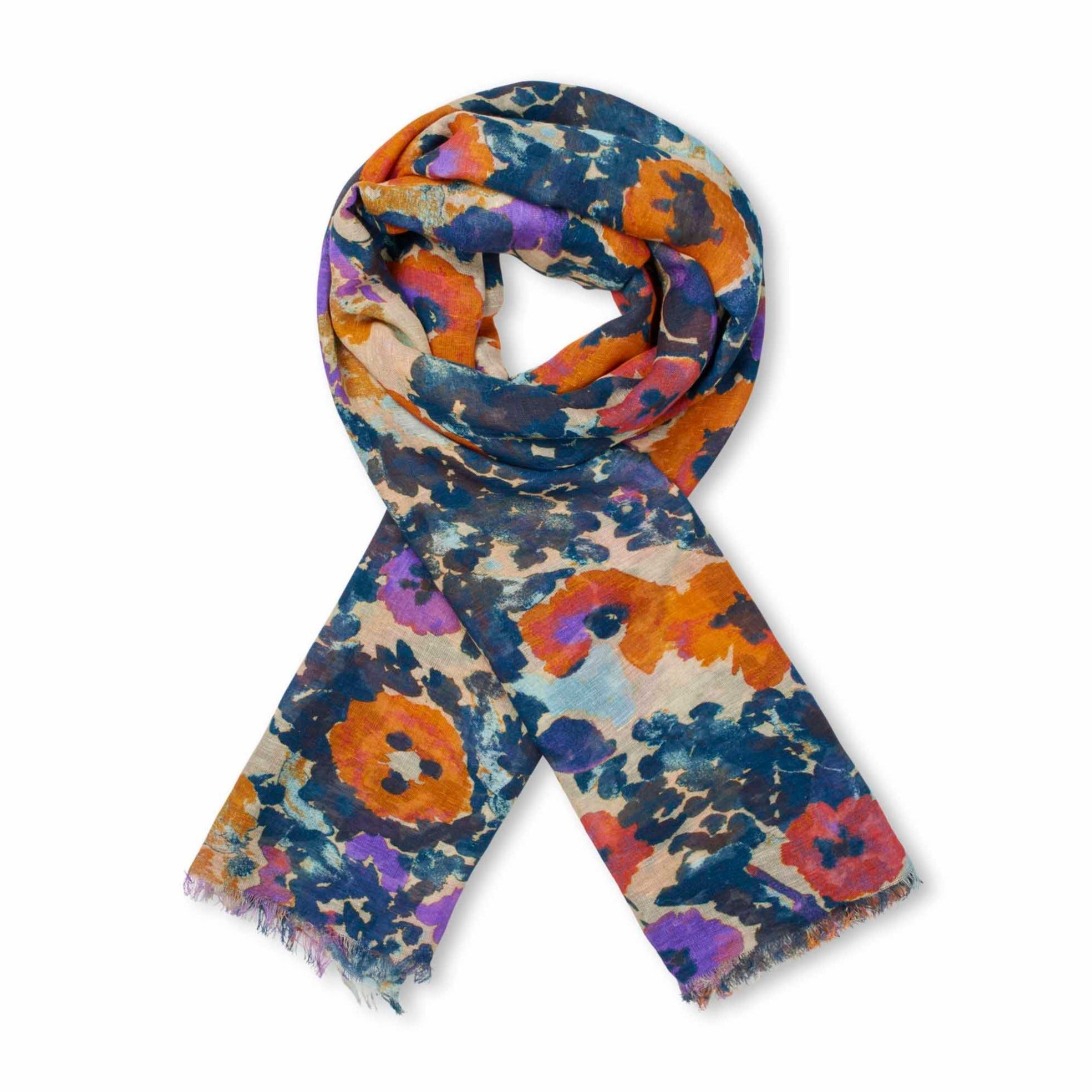 Floral print scarf in orange, purple, and teal on a beige background.
