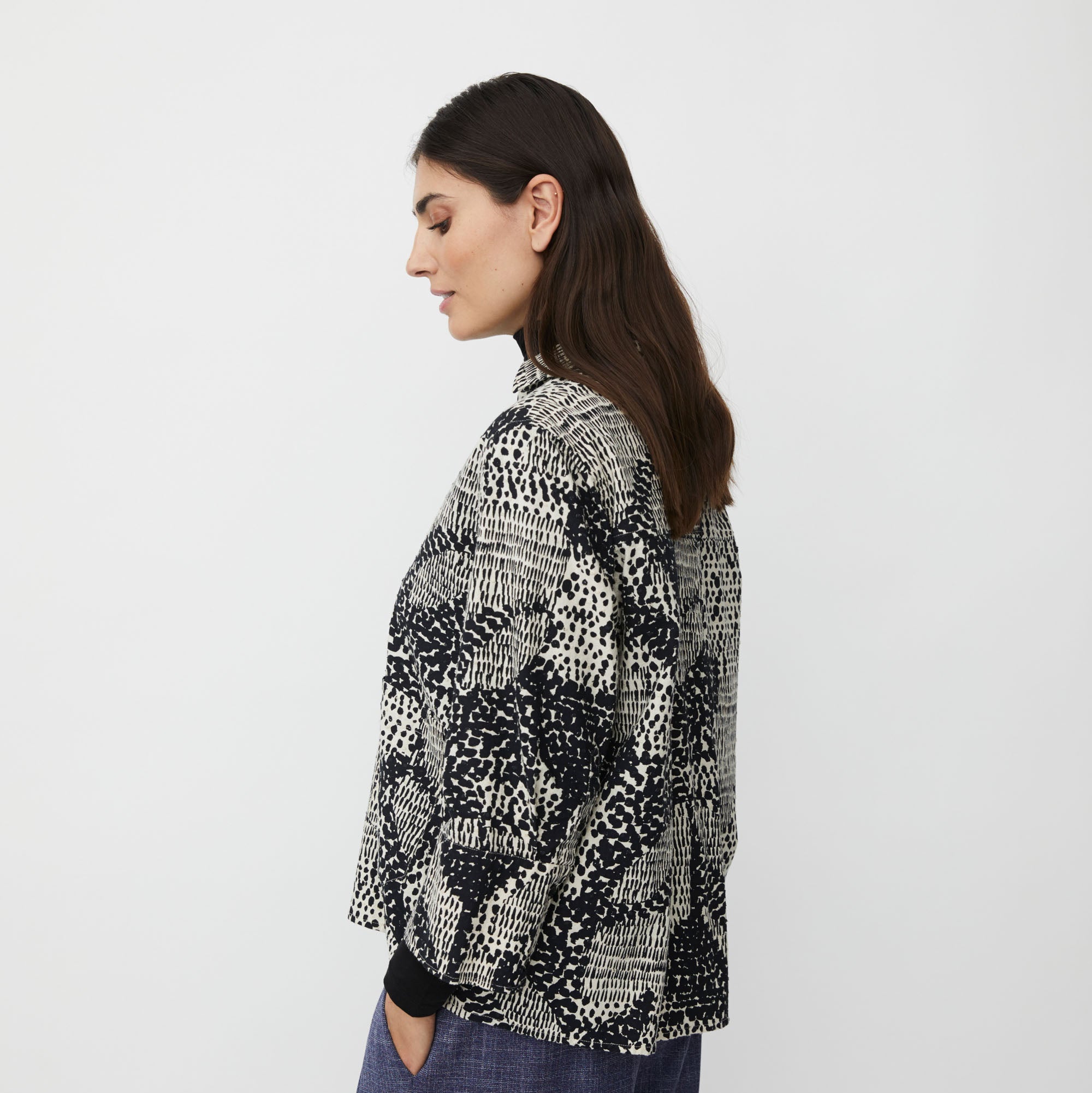 Woman wearing a patterned shirt on a plain background