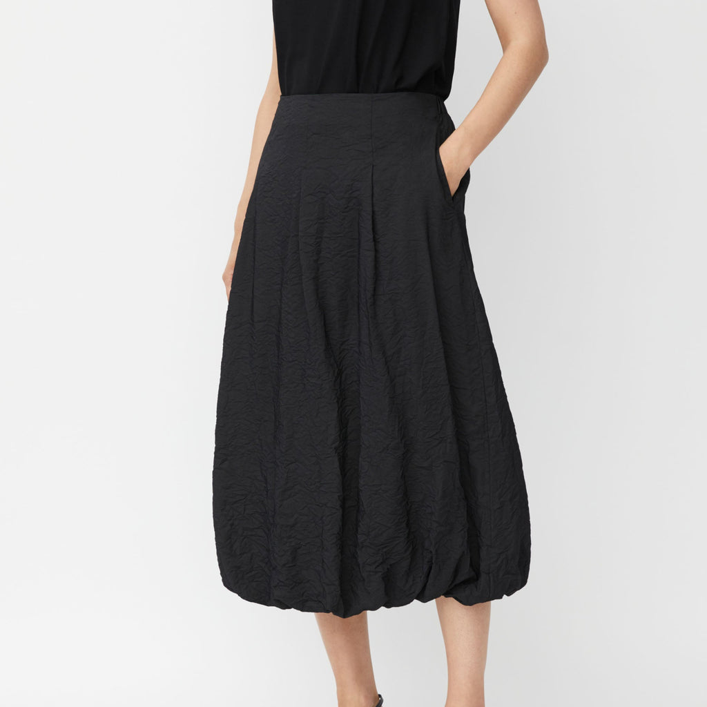 Black midi skirt with a textured, bubble hem and pockets.