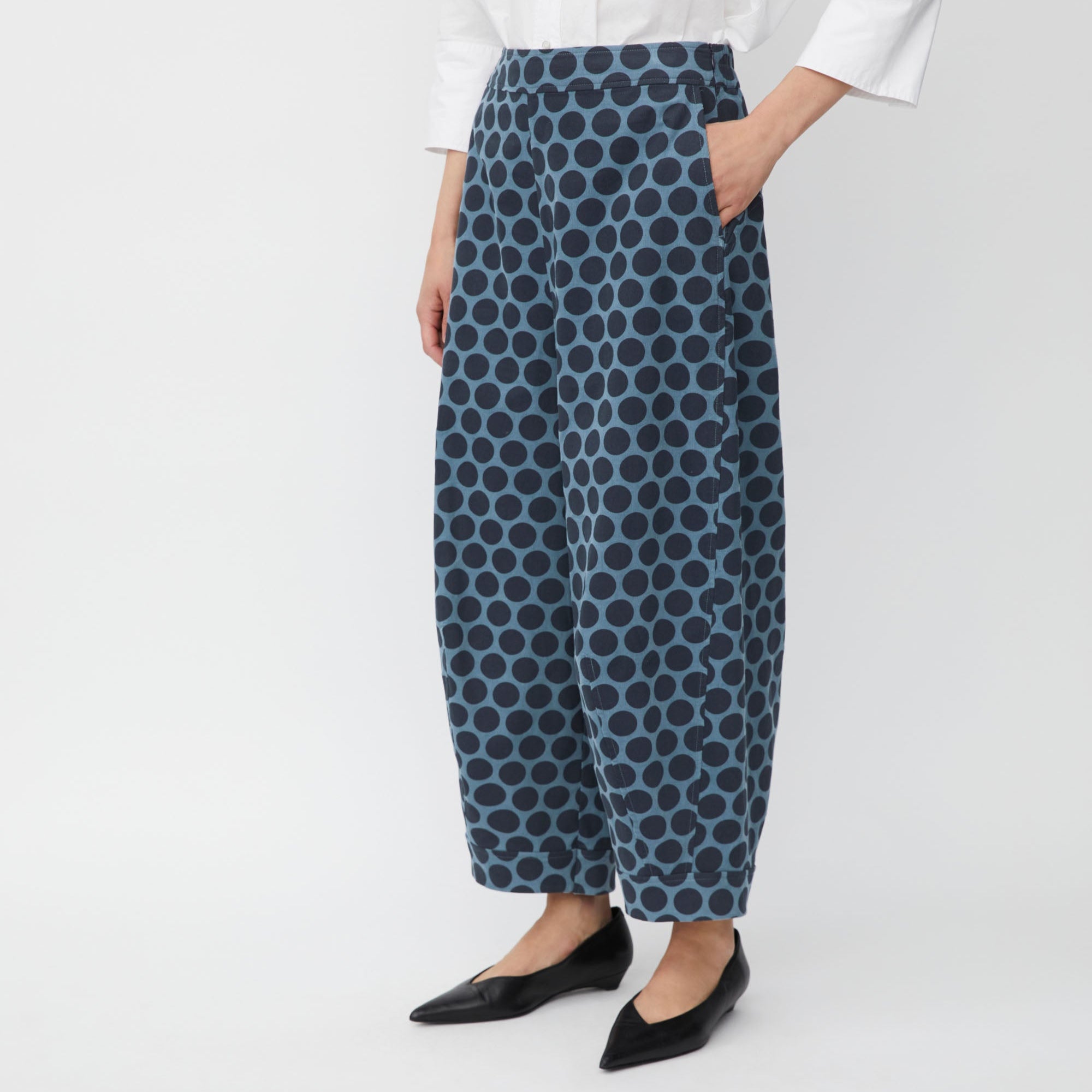 Person wearing blue polka dot pants on a white background