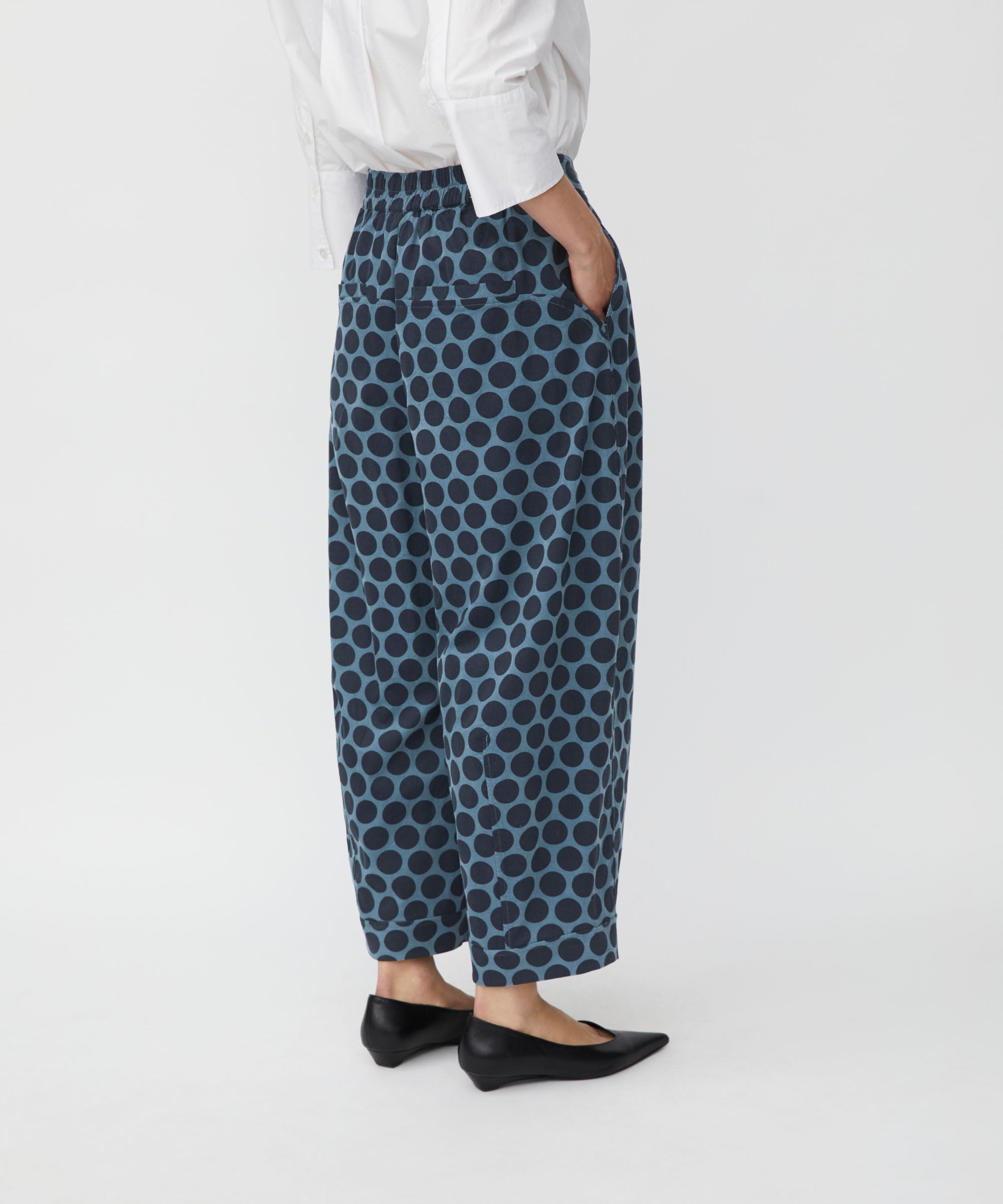 Person wearing blue patterned pants on a white background
