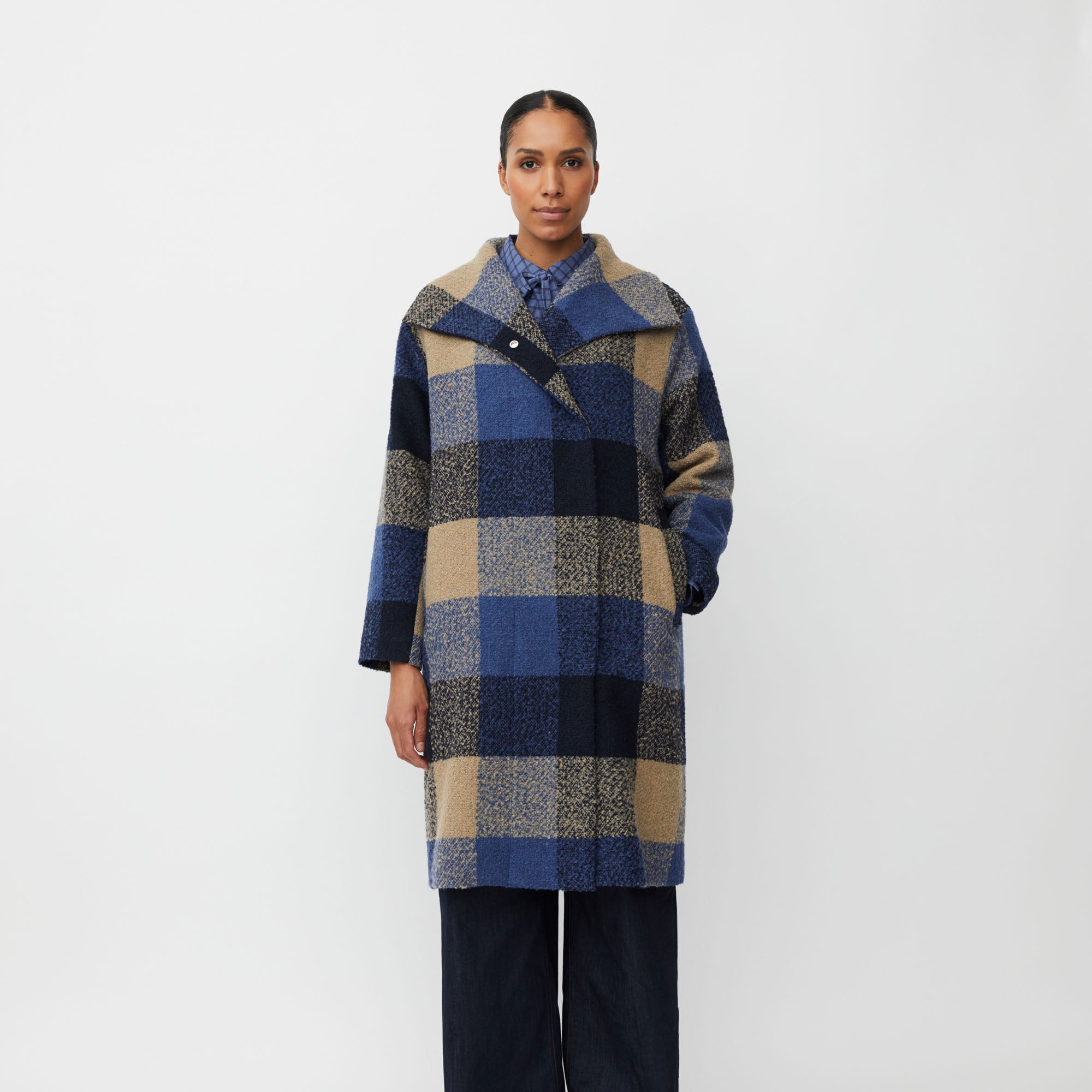 Person wearing a plaid coat on a white background