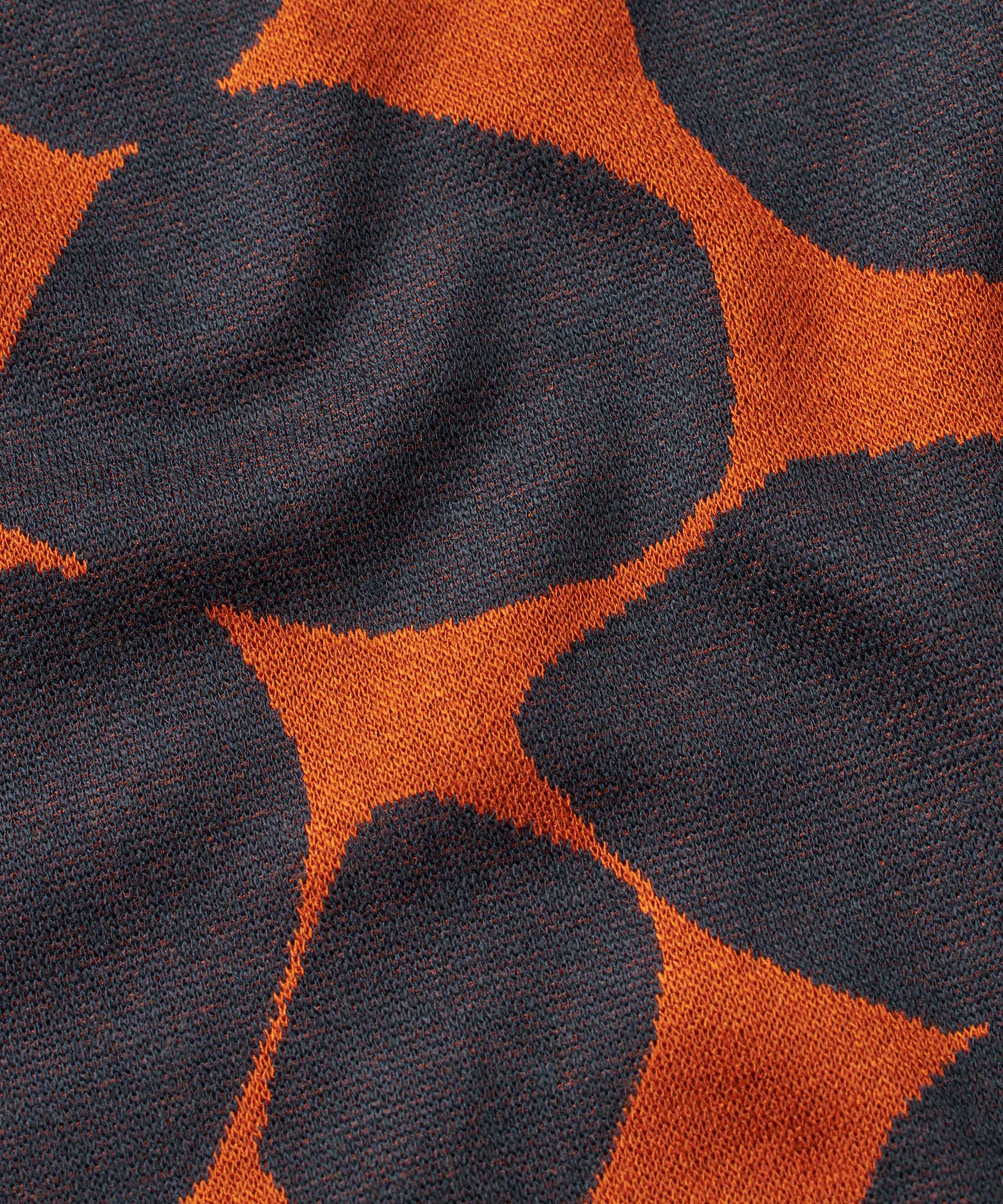 Close-up of fabric with orange and black abstract pattern