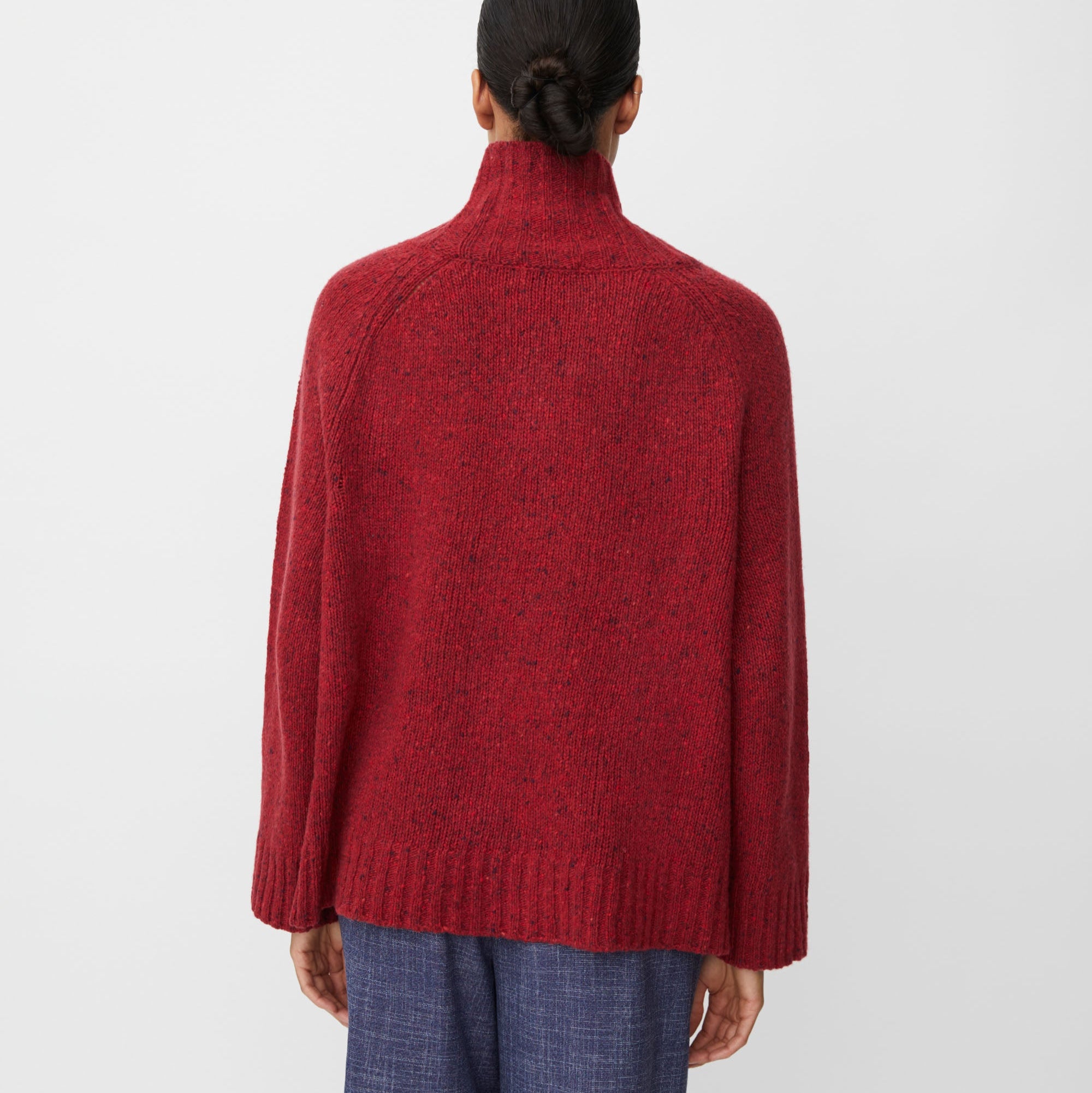 Person wearing a red sweater on a white background