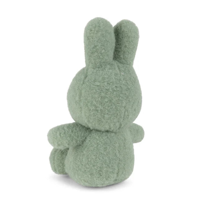 Sage green plush bunny rabbit sitting down, viewed from behind.