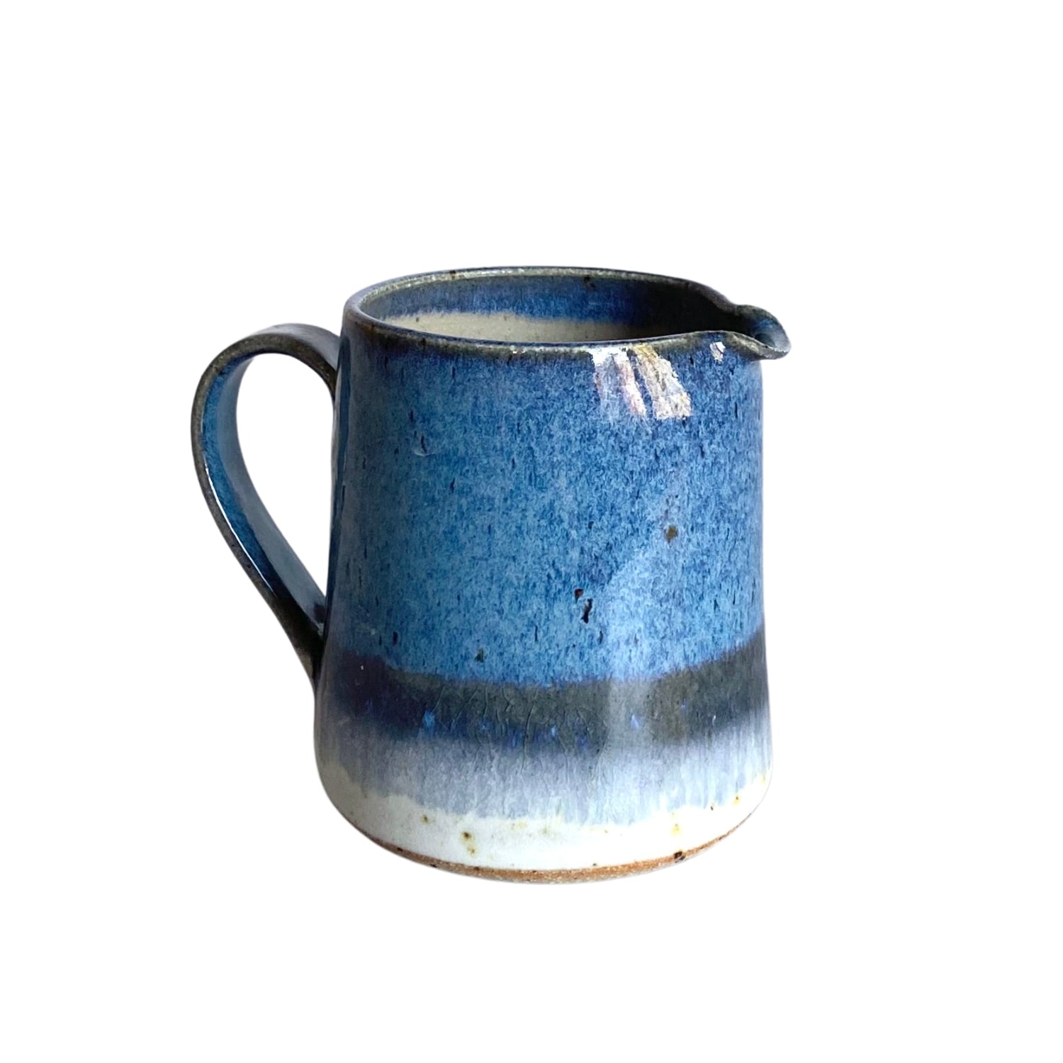 Small blue ceramic creamer with a handle, featuring a mottled glaze and a lighter band near the base.