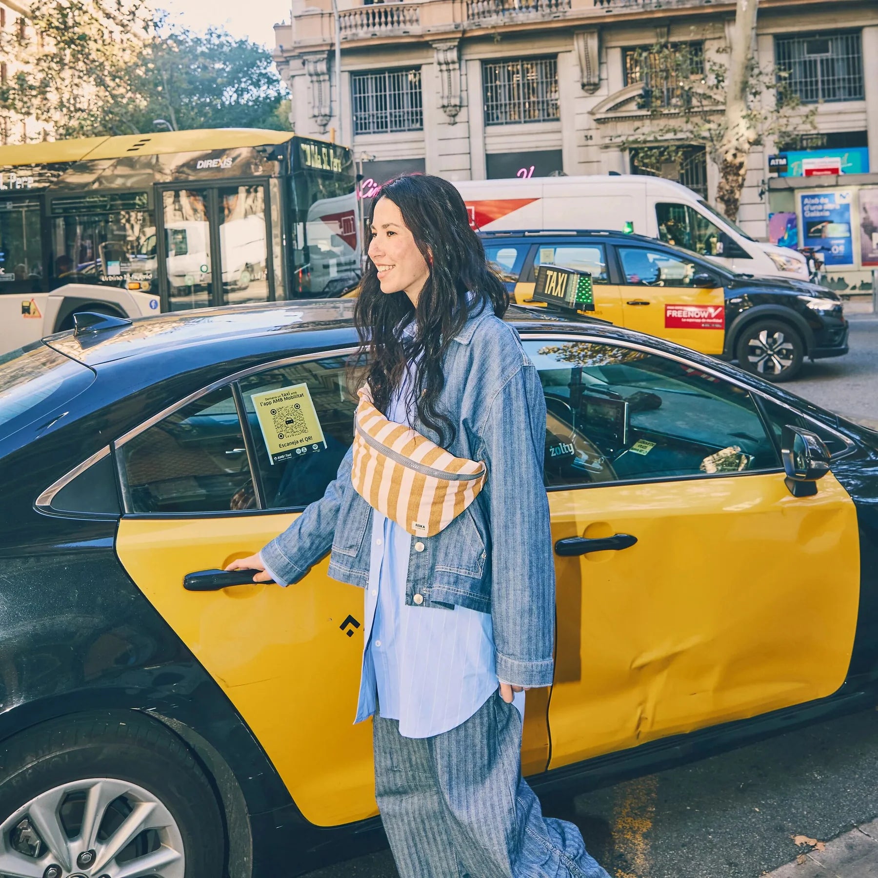 Woman getting into a yellow taxi in an urban setting