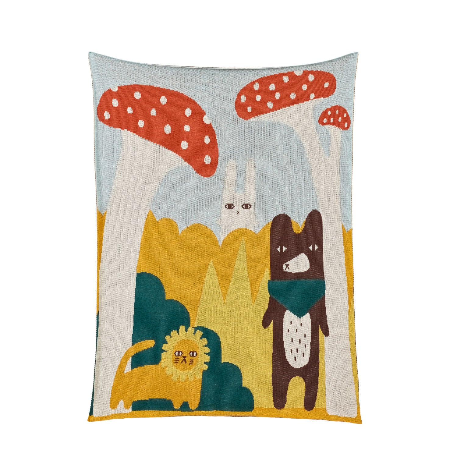Colorful blanket by Donna Wilson featuring playful animals against a backdrop of red mushrooms and greenery.