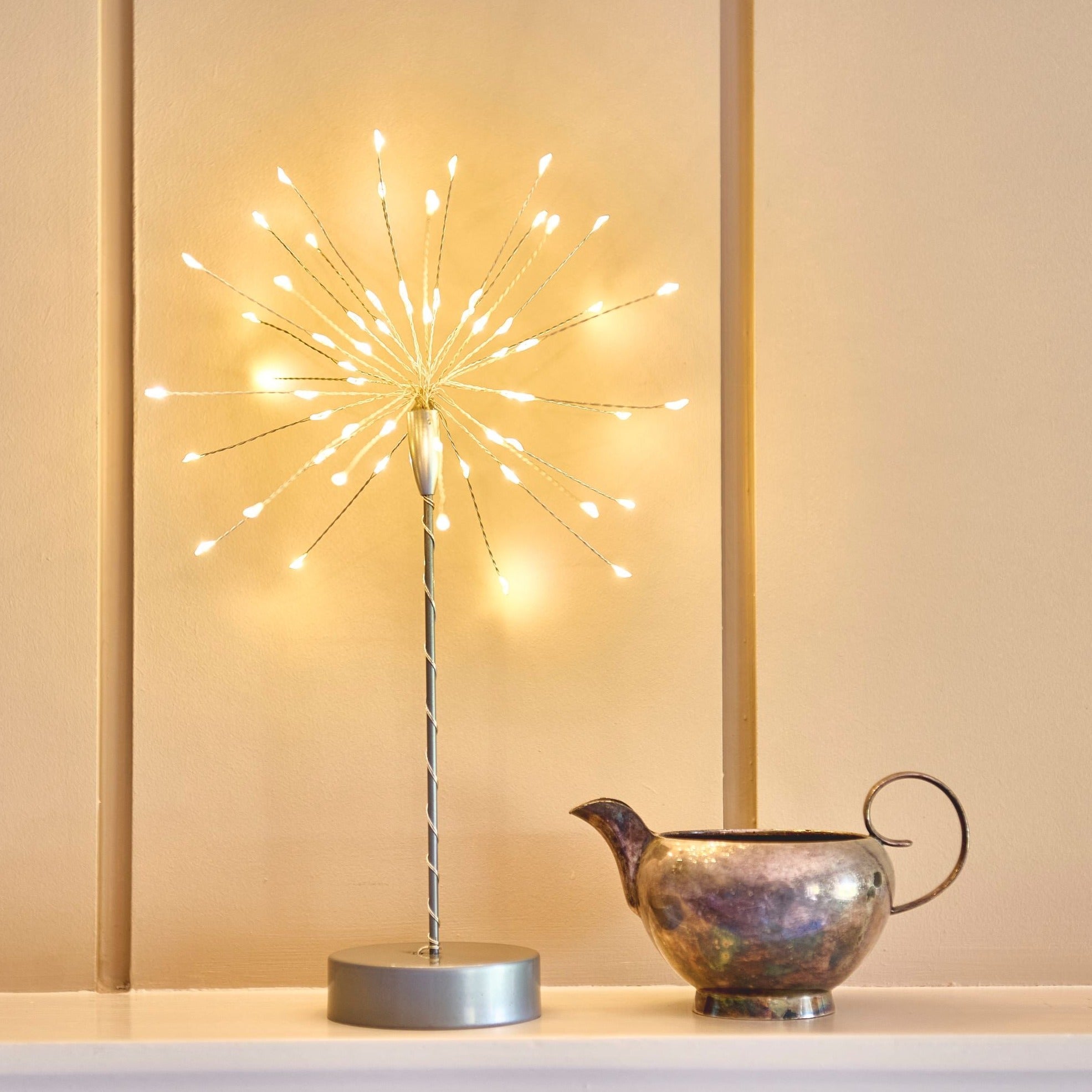 Illuminated tabletop decoration;  gold wire spokes with warm white LED lights radiating from a central stem, mounted on a