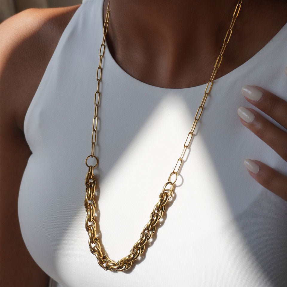 Gold necklace featuring a long paperclip chain and a shorter, thick twisted chain section.