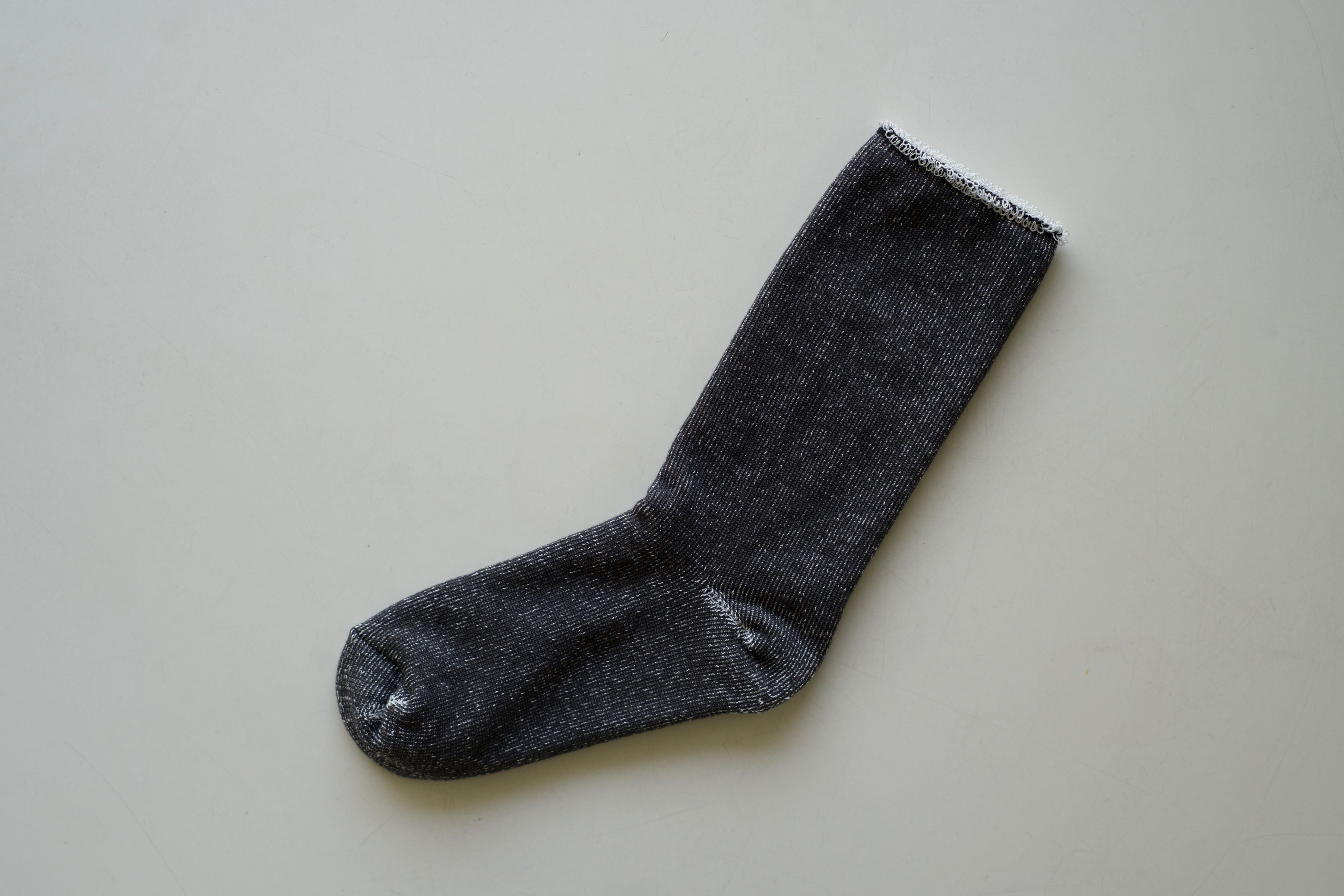 Dark gray sock with subtle silver flecks, ribbed texture, and white top trim.