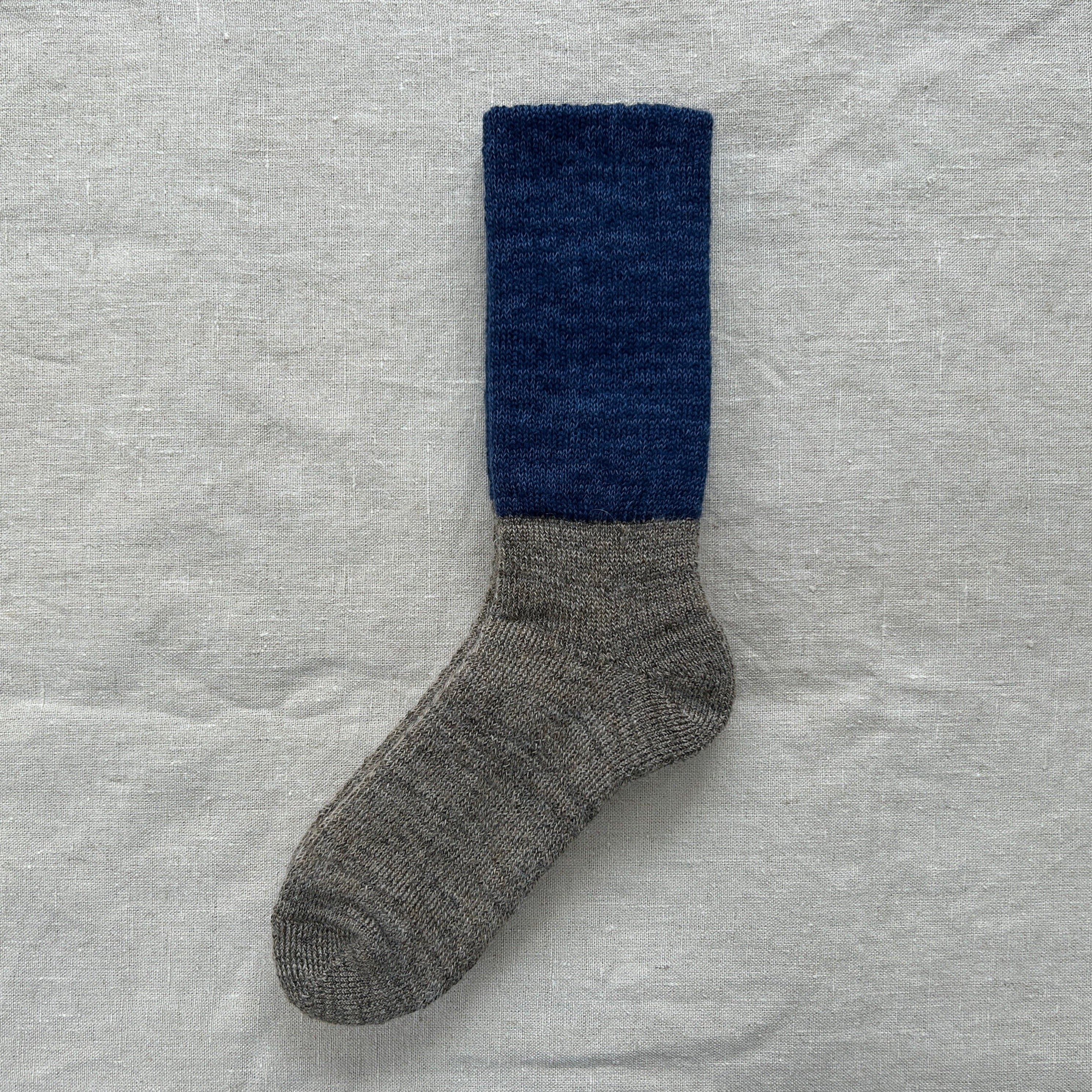 Two-toned wool sock; dark blue top, light grey bottom.