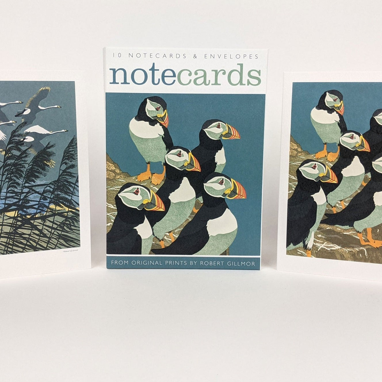 Ten notecards and envelopes featuring a group of puffins on a teal background, from original prints by Robert Gillmor.