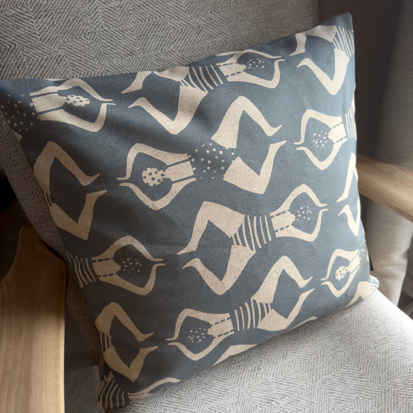 Dark gray cushion with a repeating pattern of beige stylized female figures in swimsuits.