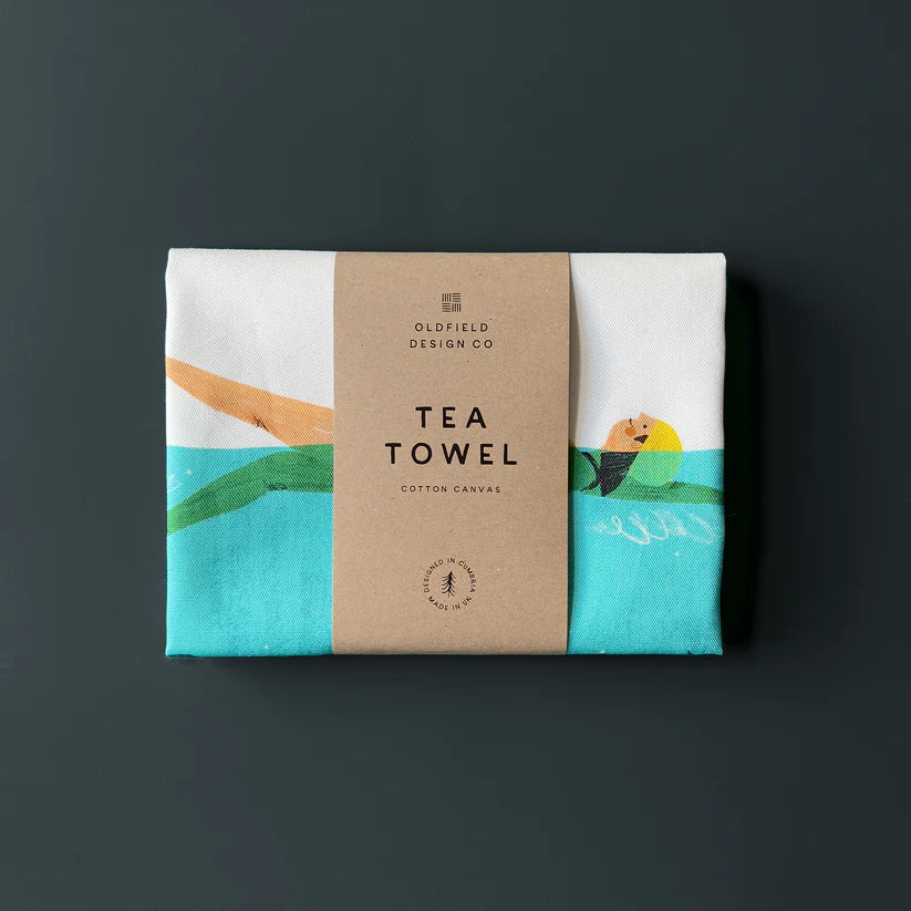 Cotton canvas tea towel featuring an illustration of a person swimming in turquoise water.