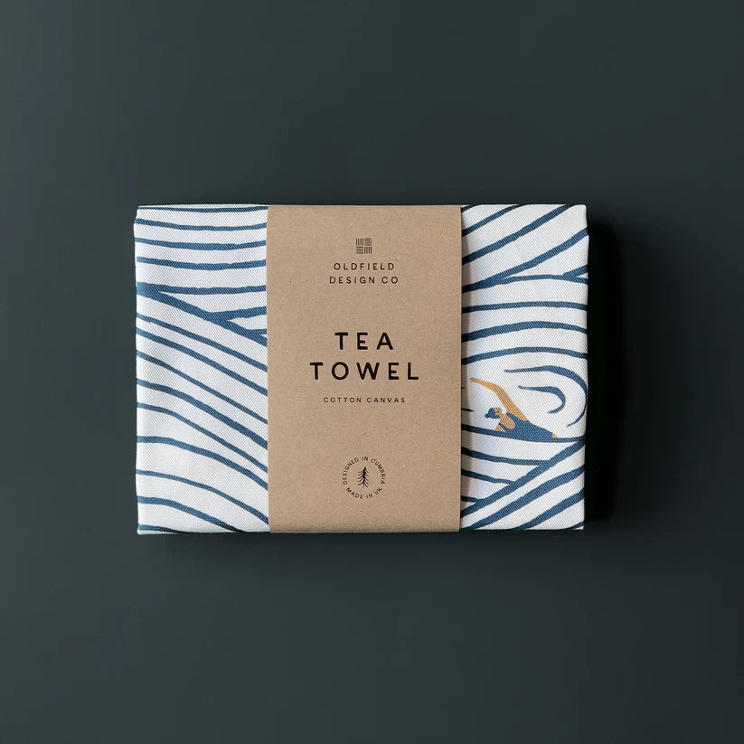 White cotton canvas tea towel with navy blue wavy lines and a small illustration of a swimmer.