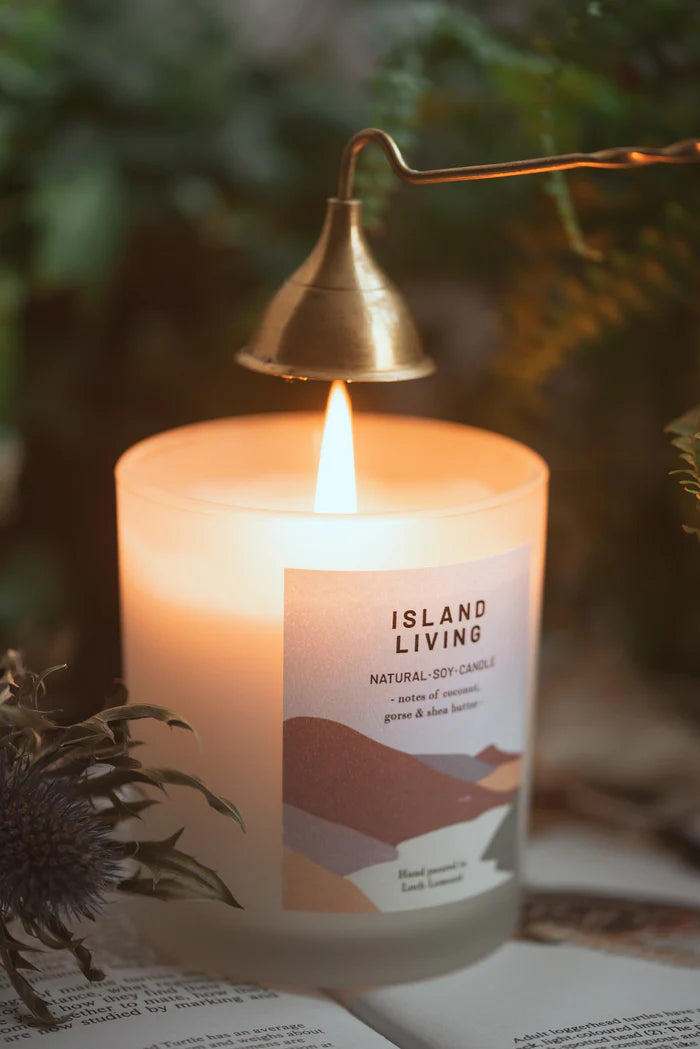 Lit Island Living natural soy candle in frosted glass jar with abstract label; brass candle lighter.