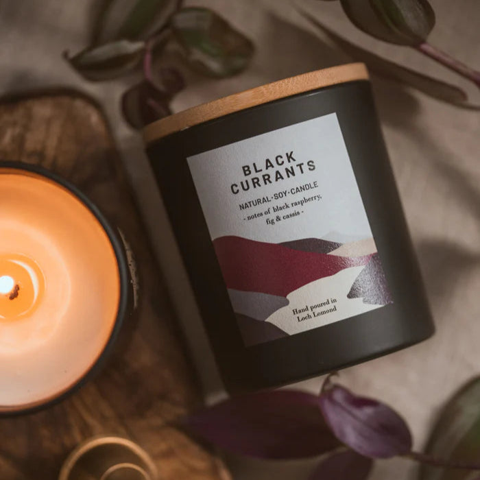 Black Currants natural soy candle in a black jar with a wooden lid.  Notes of black raspberry, fig & cassis.