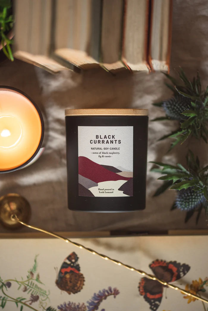 Black Currants natural soy candle in a black matte jar with a light wood lid.