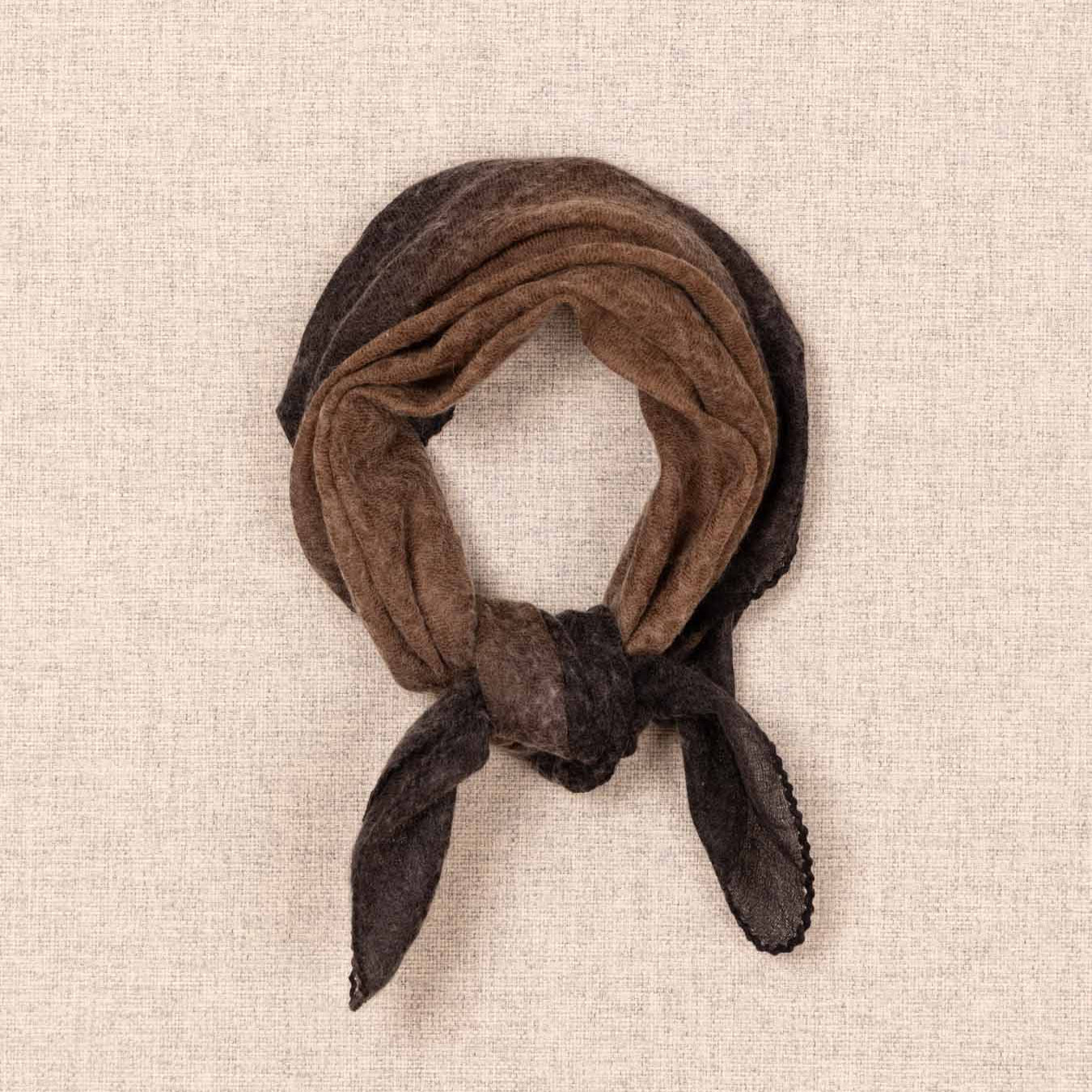 Brown scarf tied into a knot on a beige textured background