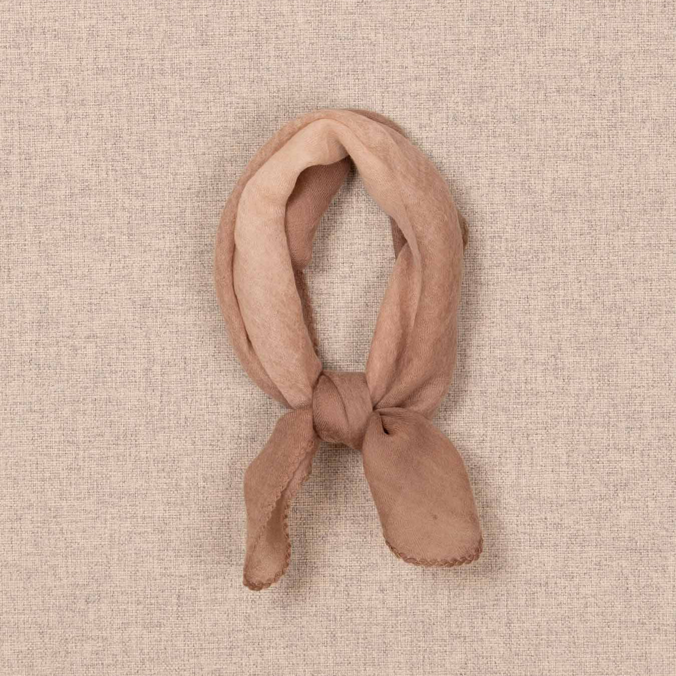 Brown knotted headband on a beige textured background