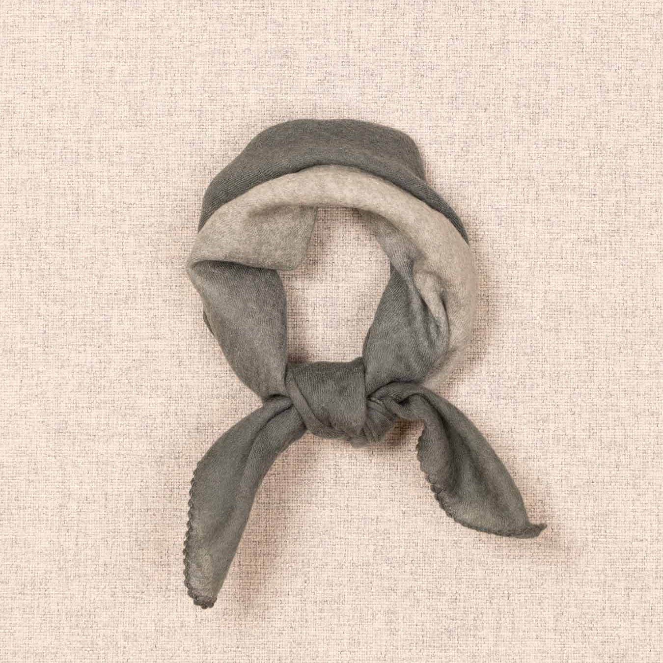 Green headscarf tied on a beige textured background