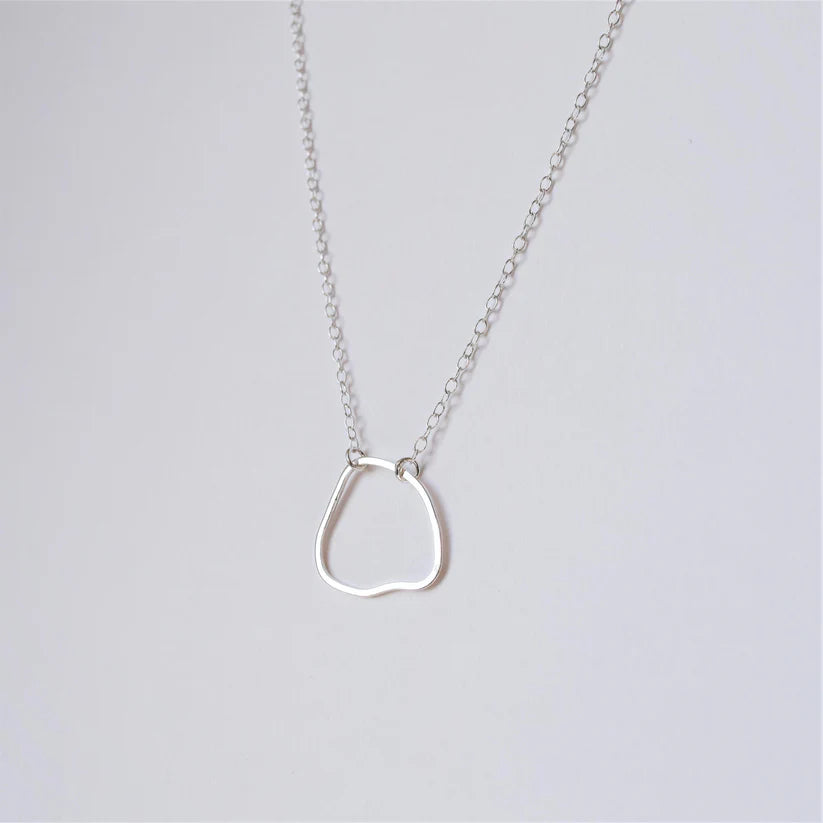 Silver necklace with an irregular, organic-shaped pendant.